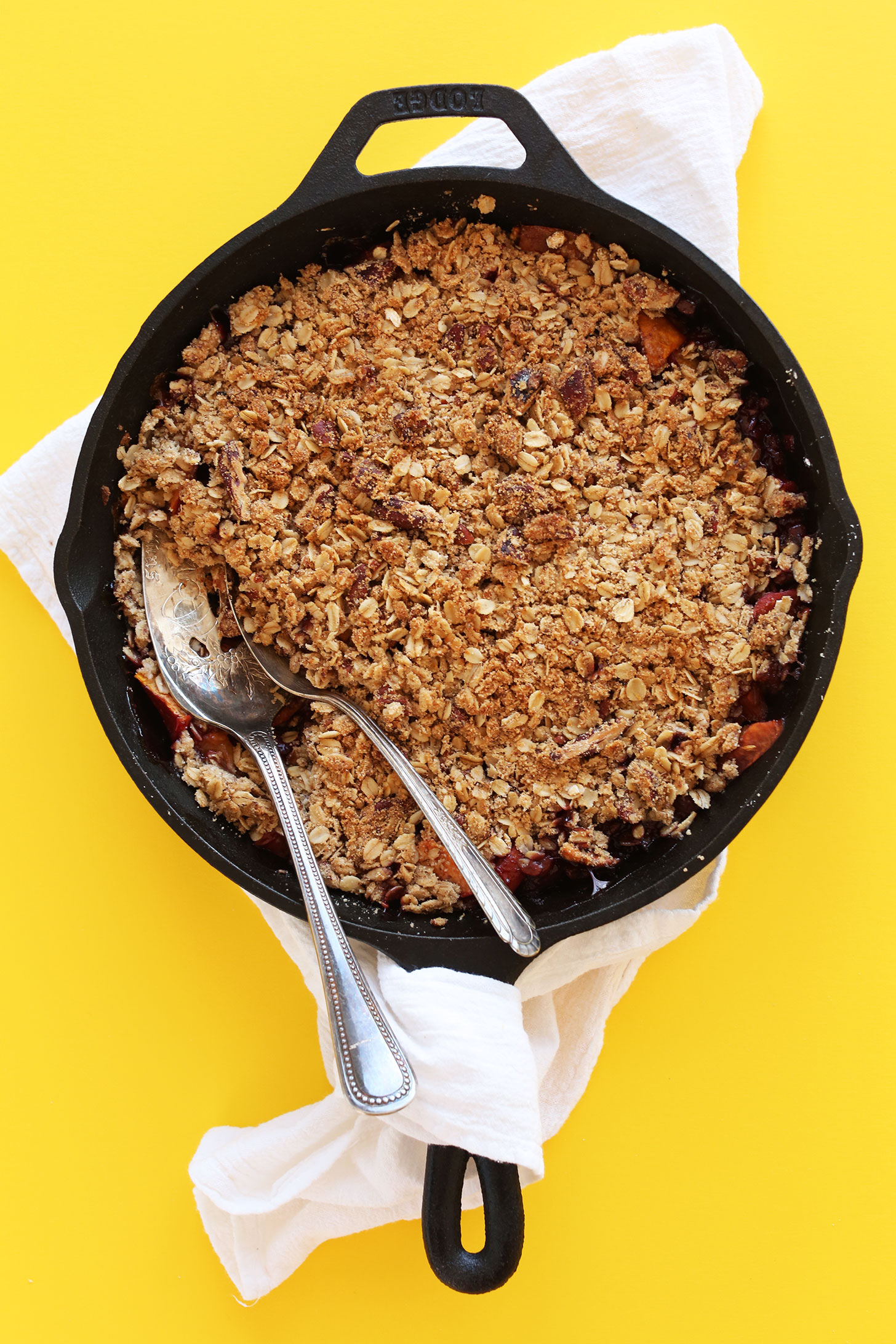 Cast-iron skillet filled with gluten-free vegan summer Peach Crisp