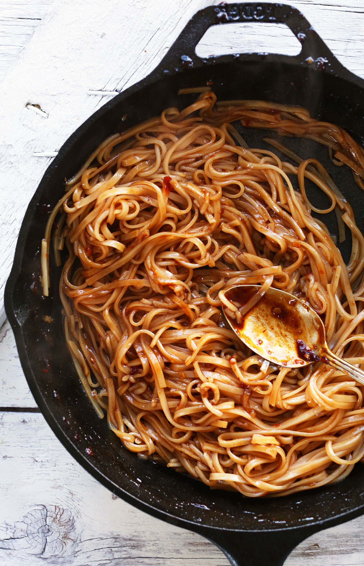 Cast-iron skillet filled with Flavorful Vegan Pad Thai noodles for adding to spring rolls