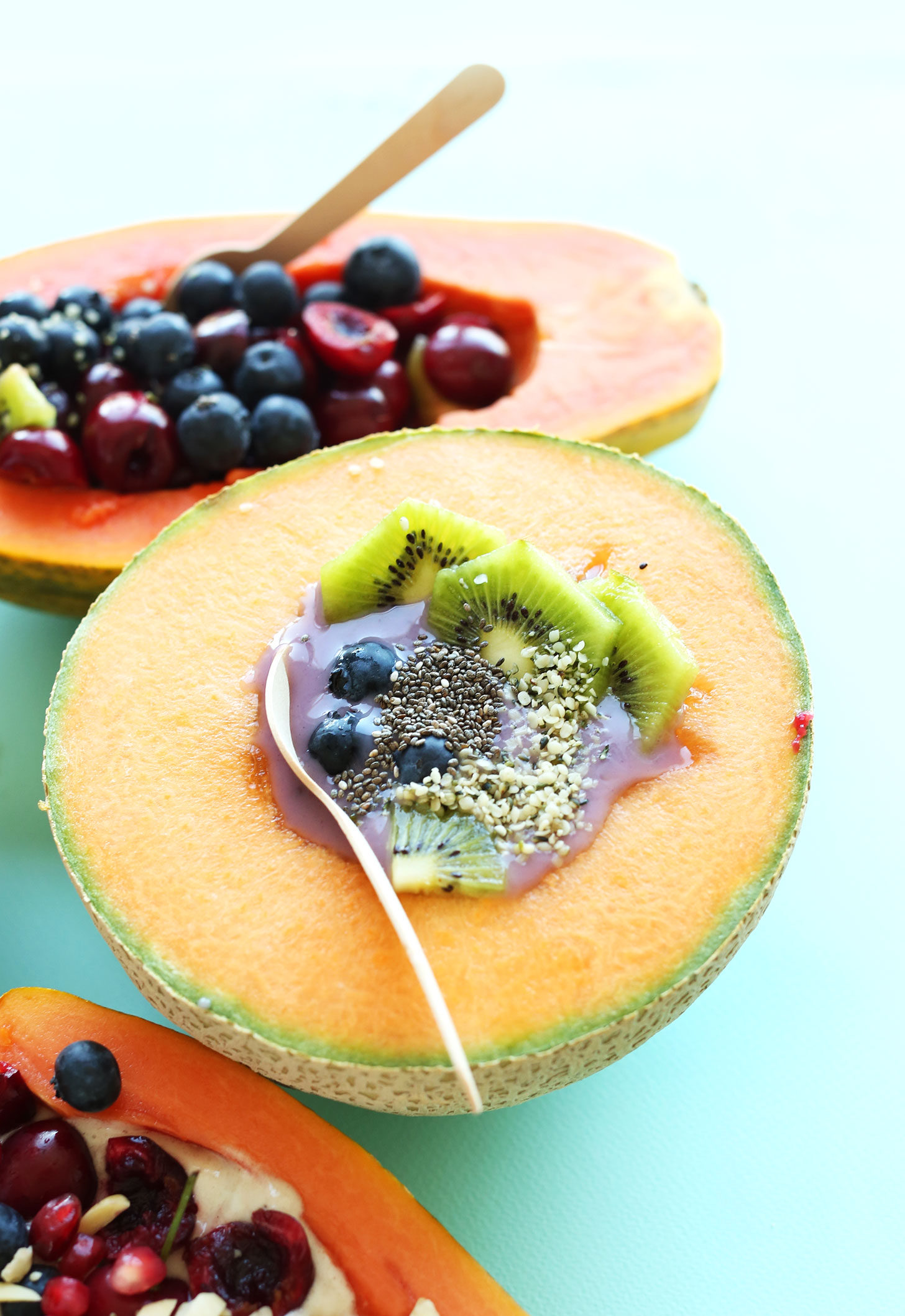 Papaya and cantaloupe halves filled with yogurt, banana ice cream, and fruit for a summer treat