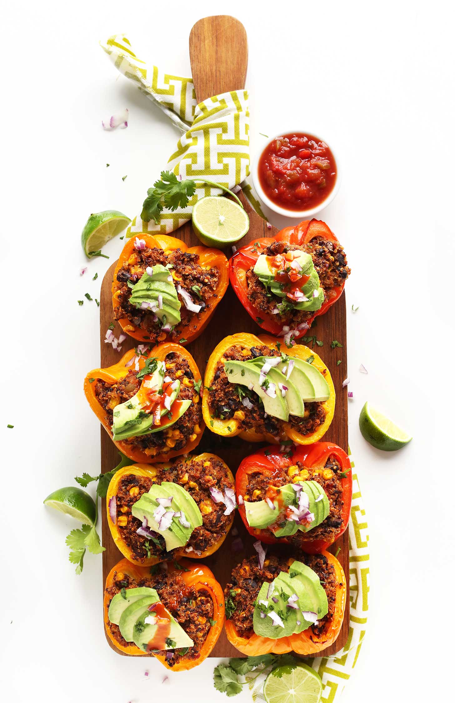 Wood platter filled with gluten-free vegan Spanish Quinoa Stuffed Peppers