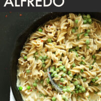 Cast iron skillet of 30-minute vegan and gluten-free Alfredo with a spoon in it