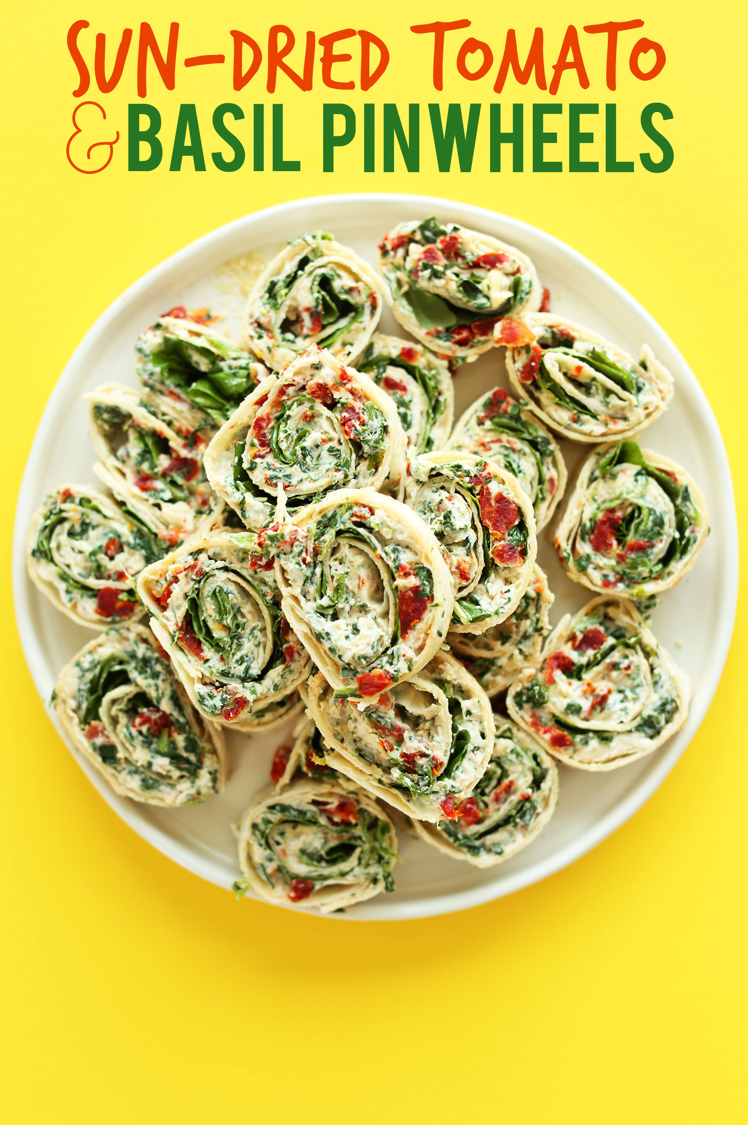 Sun-Dried Tomato and Basil Pinwheels stacked on a plate for a vegan party appetizer