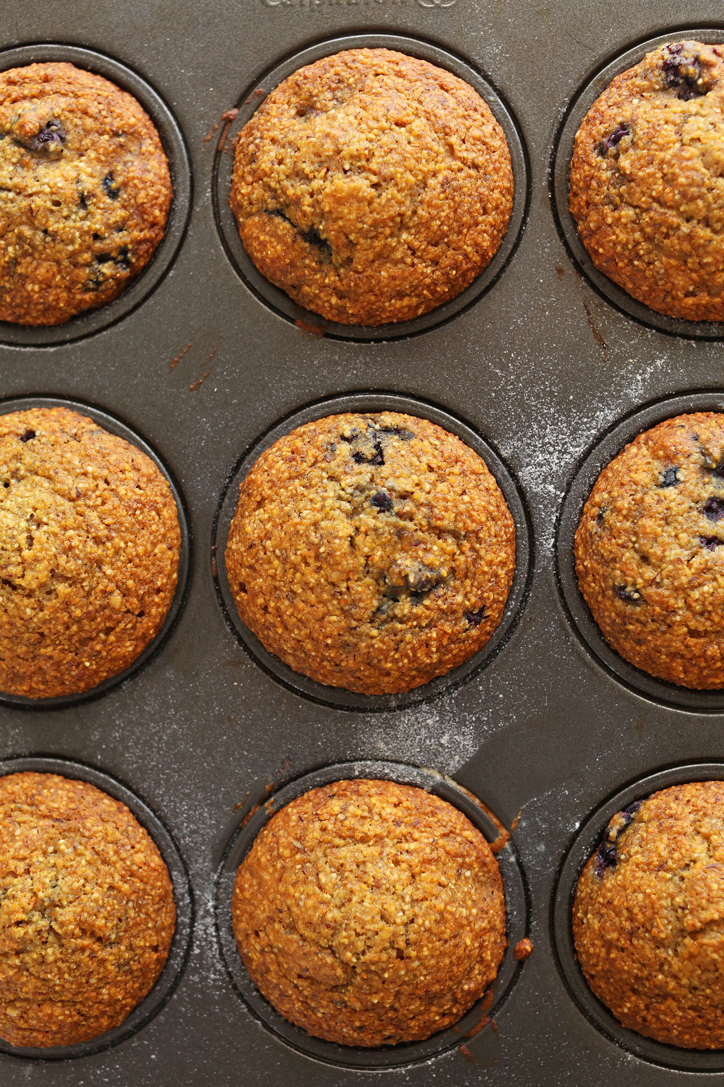 Muffin tin with perfectly baked vegan Blackberry Cornmeal Muffins