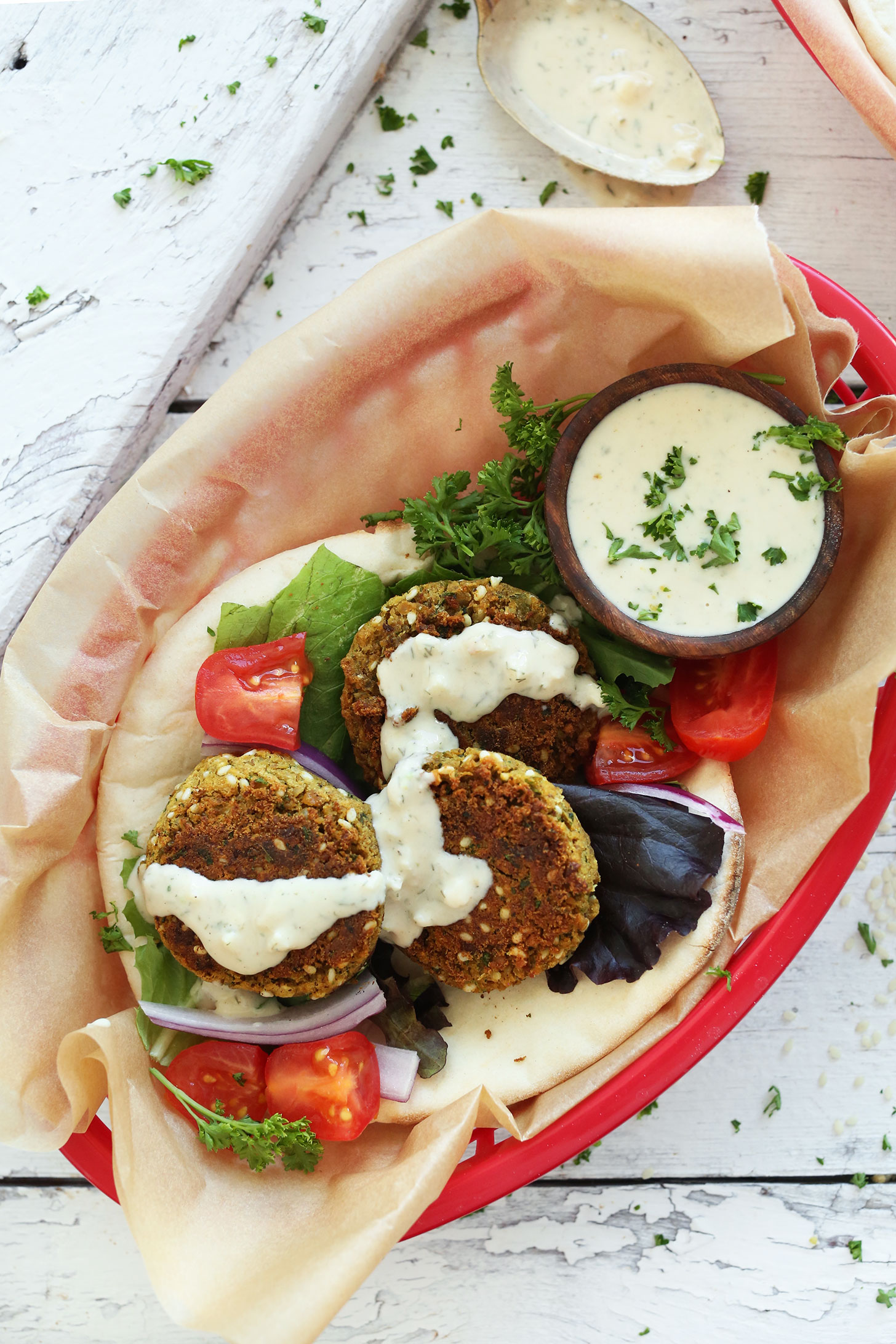 Basket filled with Vegan Falafel on pita bread with 4-ingredient dressing and fresh vegetables