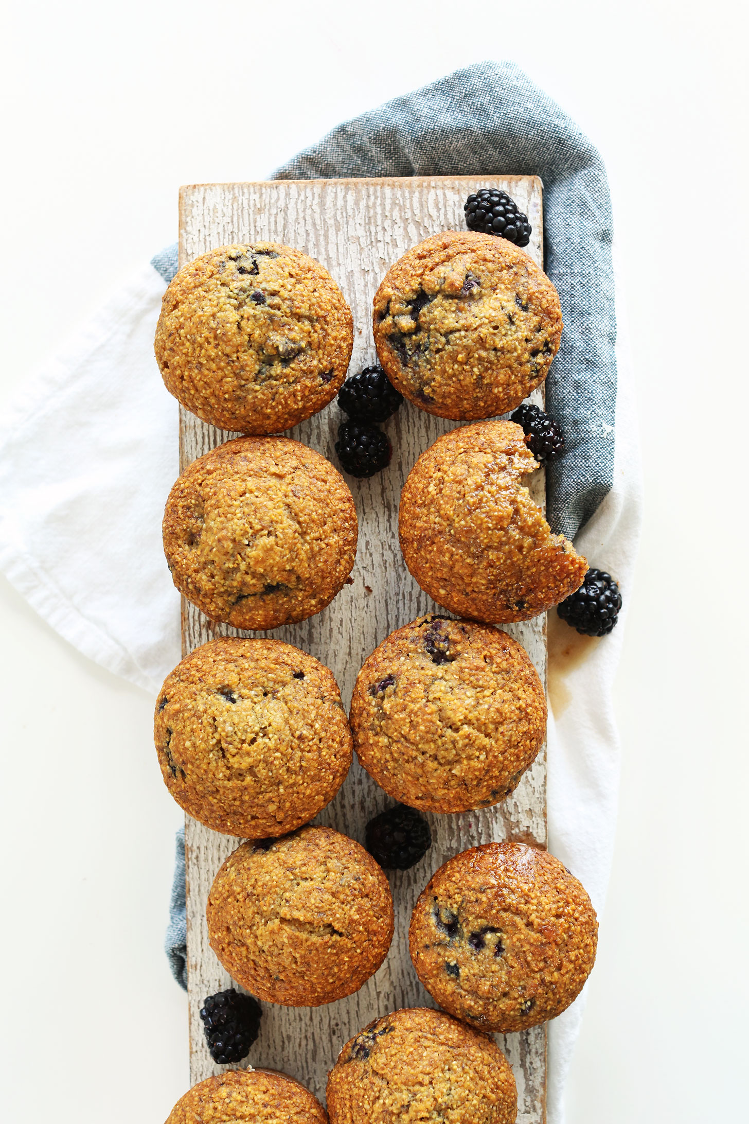 Wood plank with a batch of our vegan Blackberry Cornmeal Muffins recipe