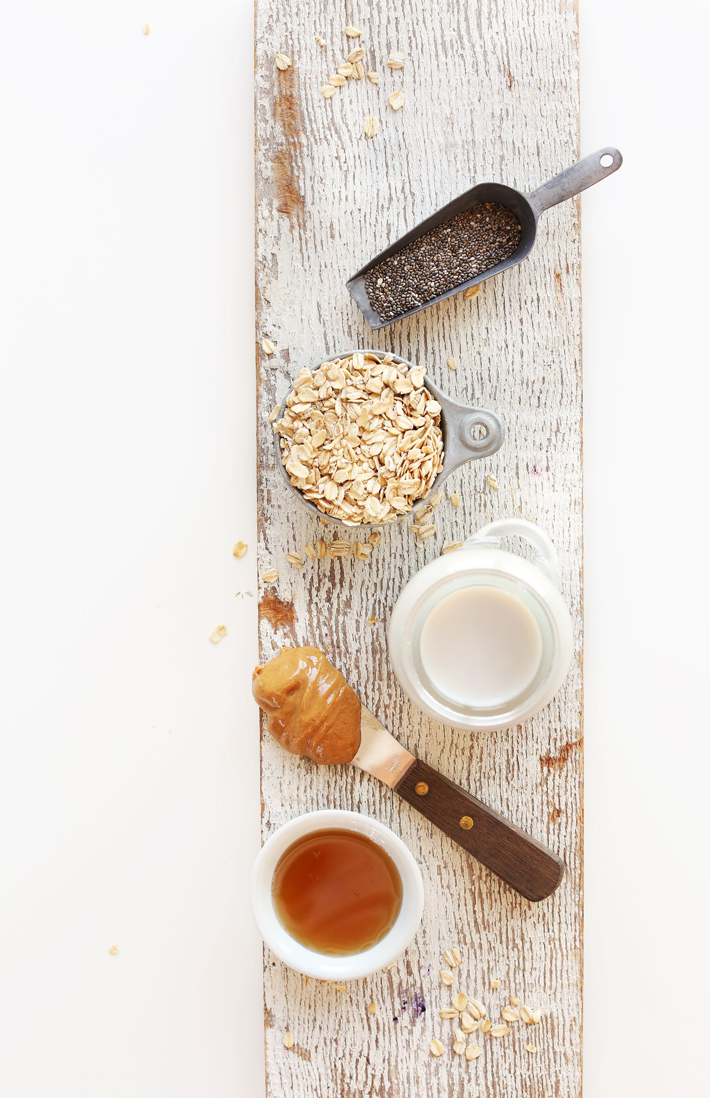 Chia seeds, oats, almond milk, peanut butter, and maple syrup for making our delicious vegan overnight oats recipe
