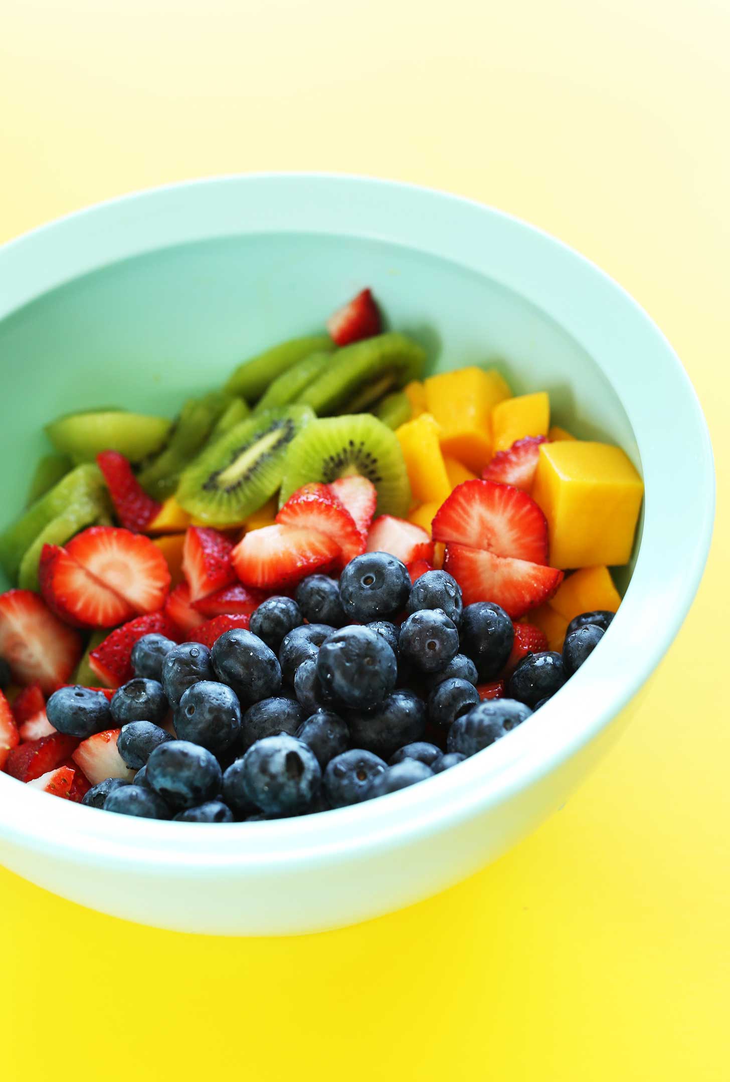 Bowl of mango, strawberries, kiwi, and blueberries for an incredible summer side dish