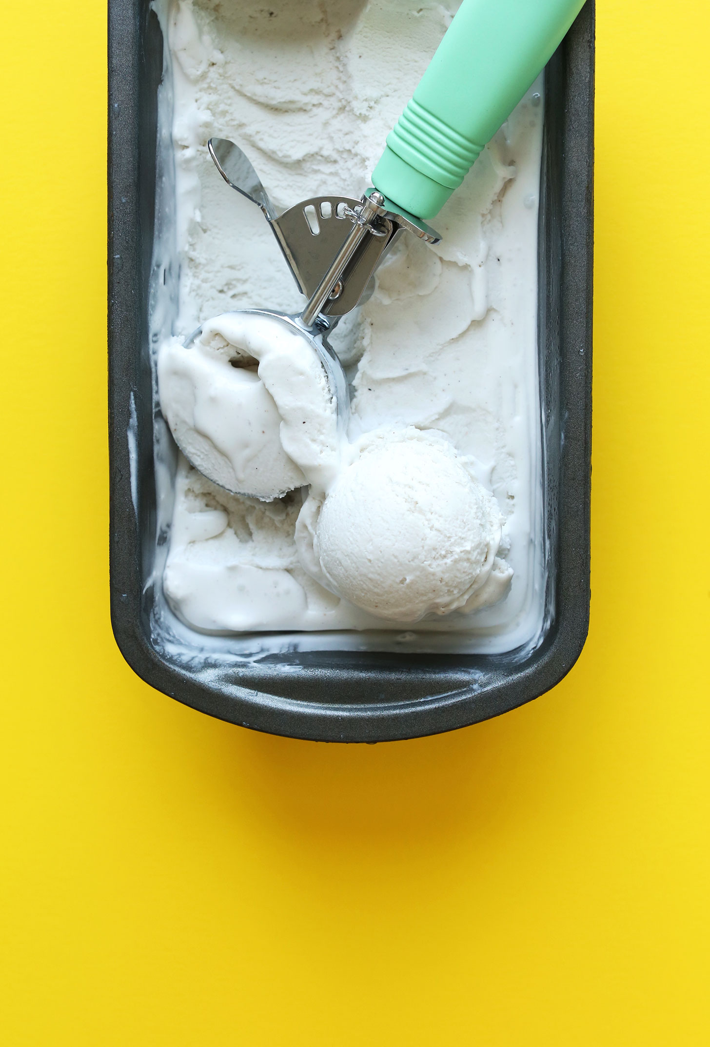 Using an ice cream scooper to grab a scoop of homemade vegan coconut ice cream