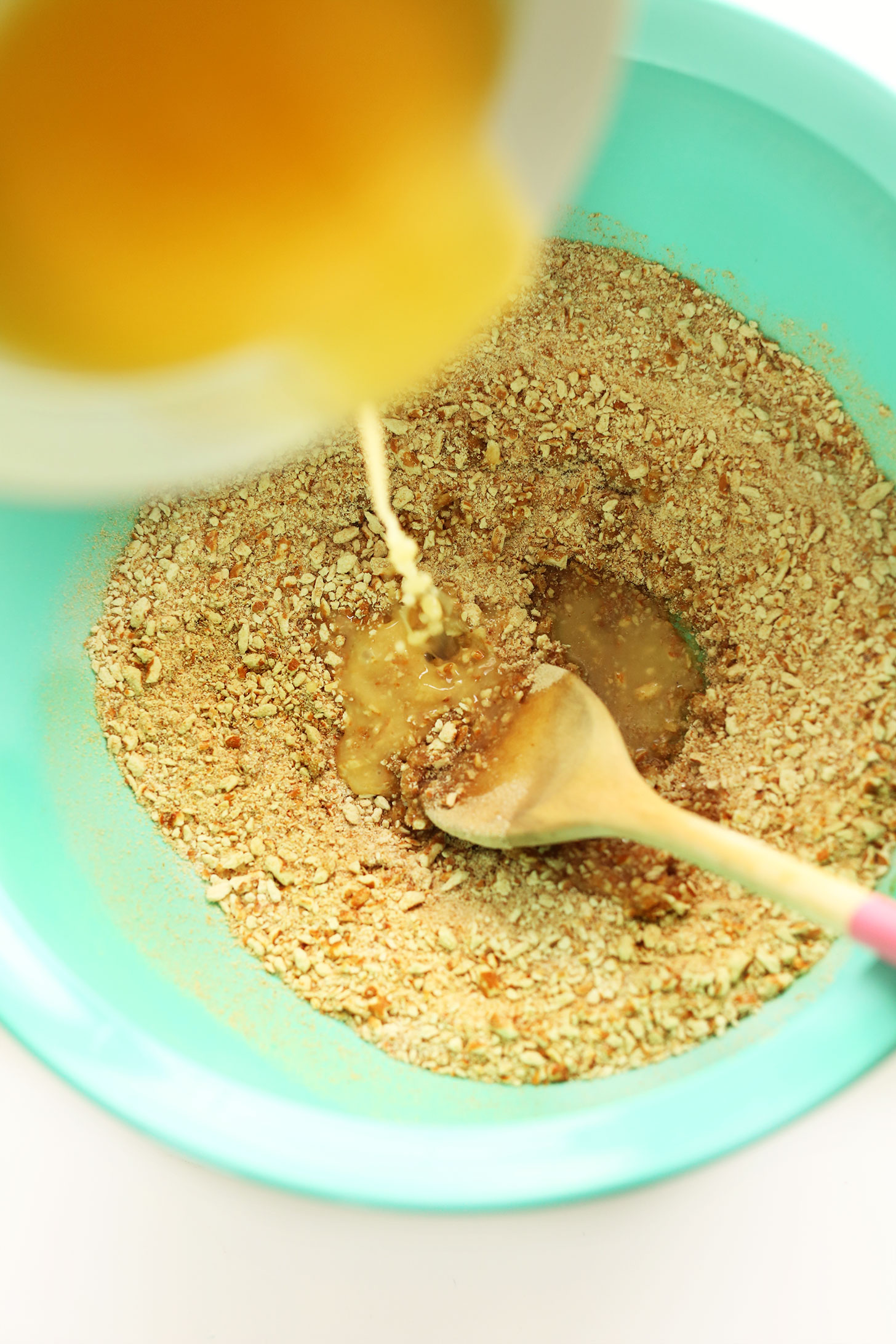 Pouring melted vegan butter into dry ingredients for the crust of Pretzel Peanut Butter Chocolate Pie