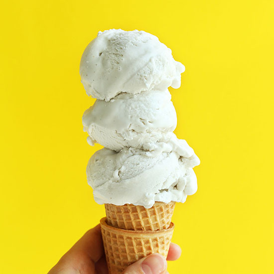Triple scooped Vanilla Bean Coconut Ice Cream on a stack of sugar cones