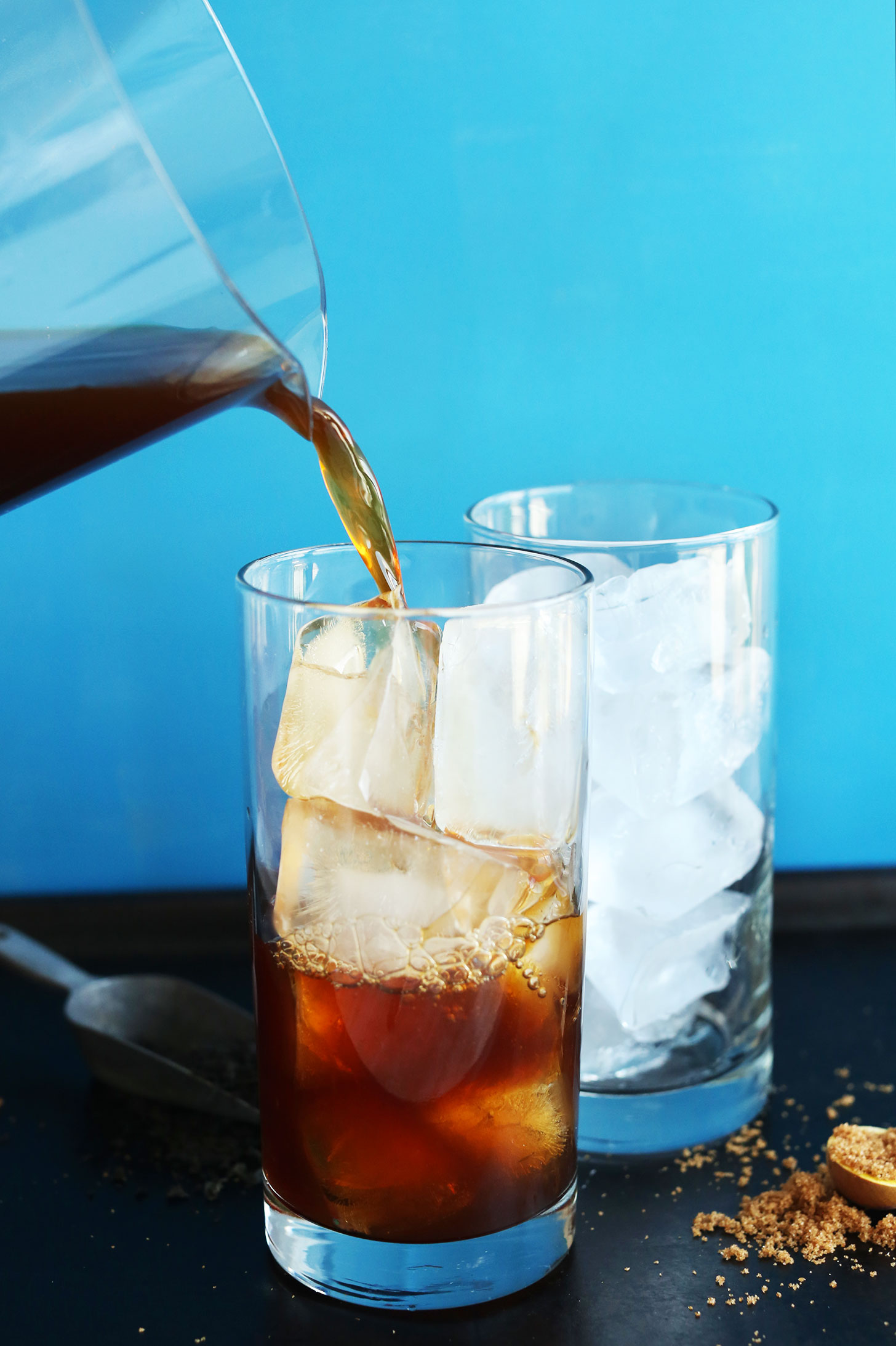 Pouring tea over ice cubes for Easy Vegan Coconut Thai Iced Tea
