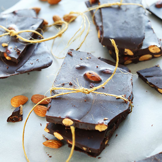 Stacks of DIY Dark Chocolate Almond Bars tied with twine