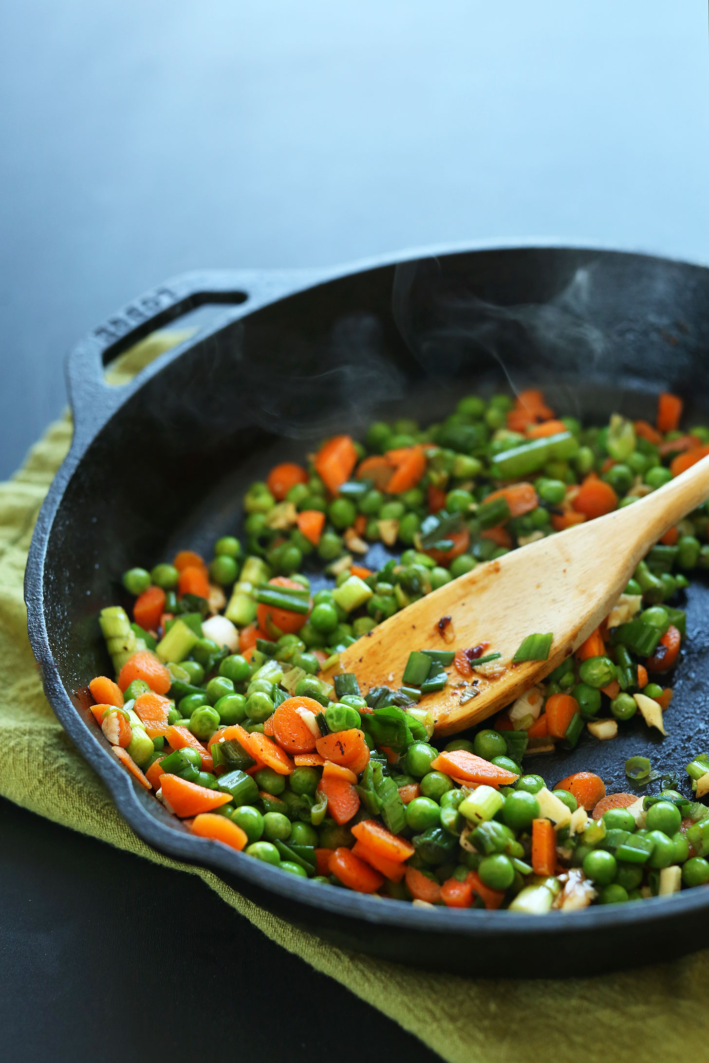 Cooking vegetables in a cast-iron skillet for vegan Chinese Fried Rice
