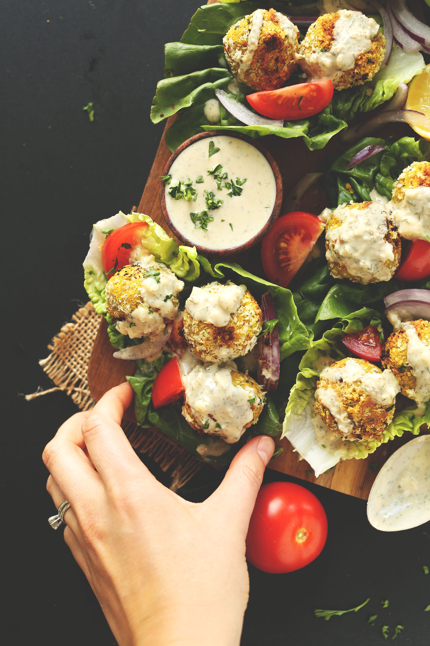 Grabbing Turmeric Chickpea Fritters wrapped in a lettuce leaf