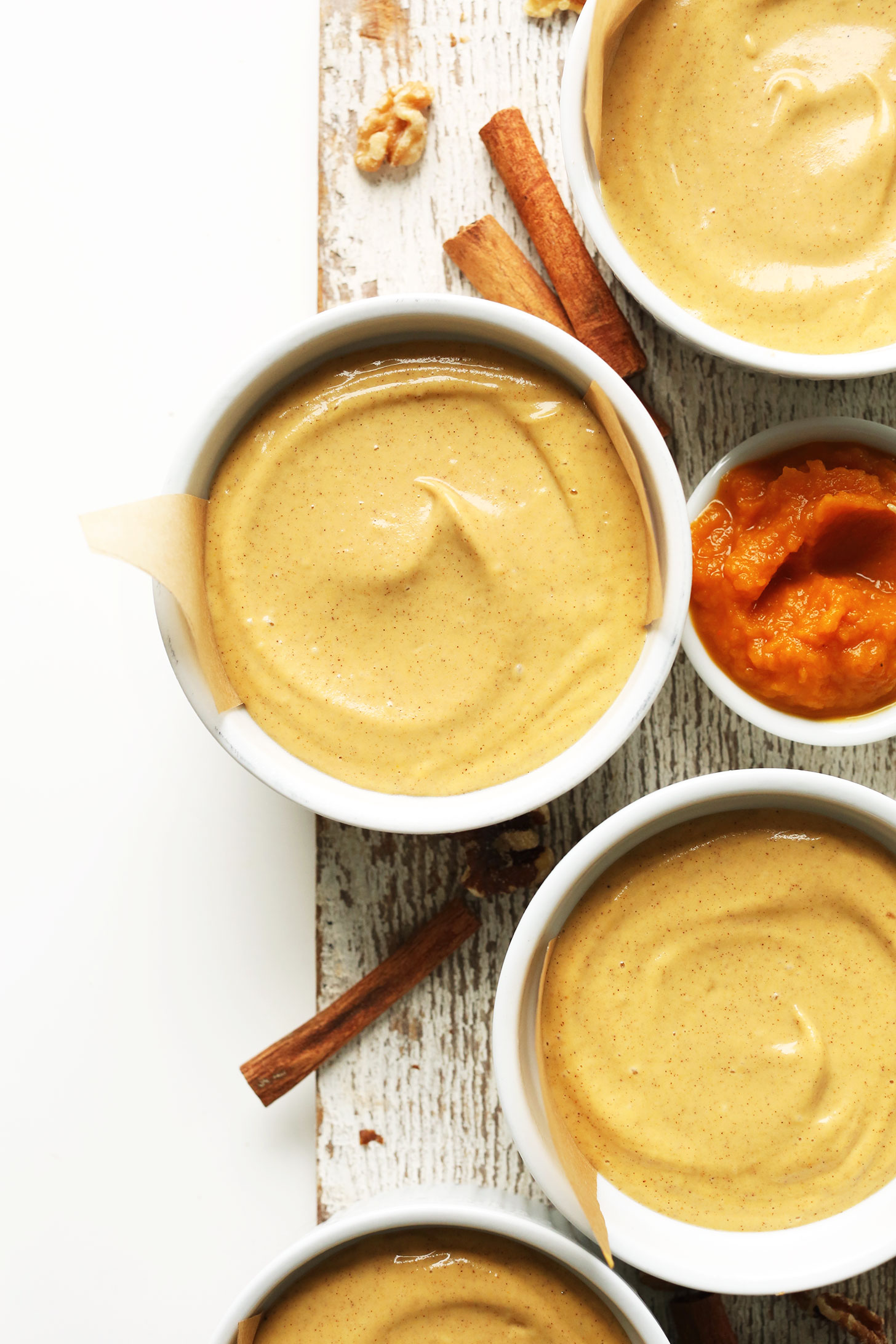 Ramekins filled with our creamy gluten-free Vegan Pumpkin Cheesecakes