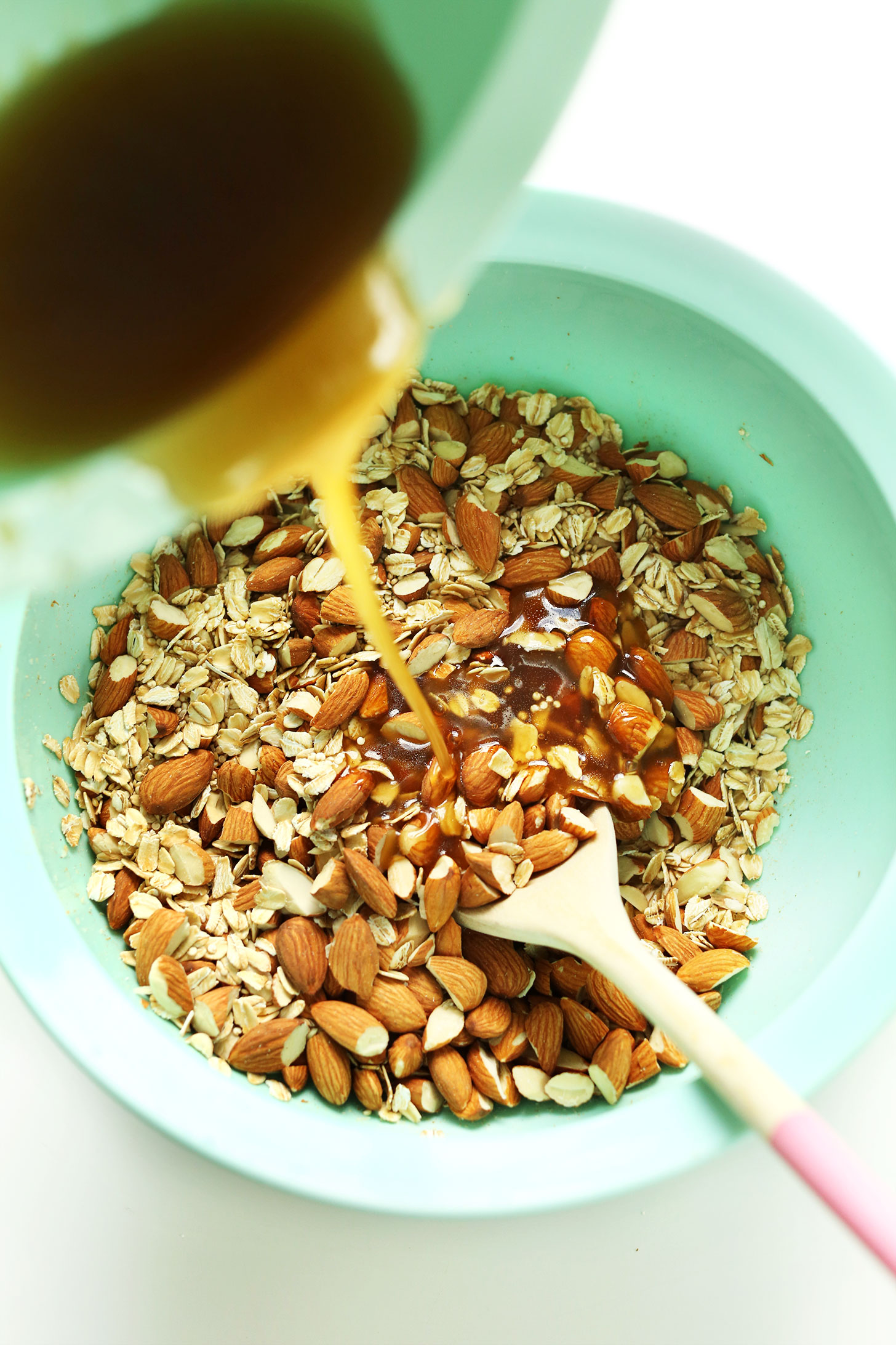 Pouring wet ingredients into dry for our homemade Quinoa Granola recipe