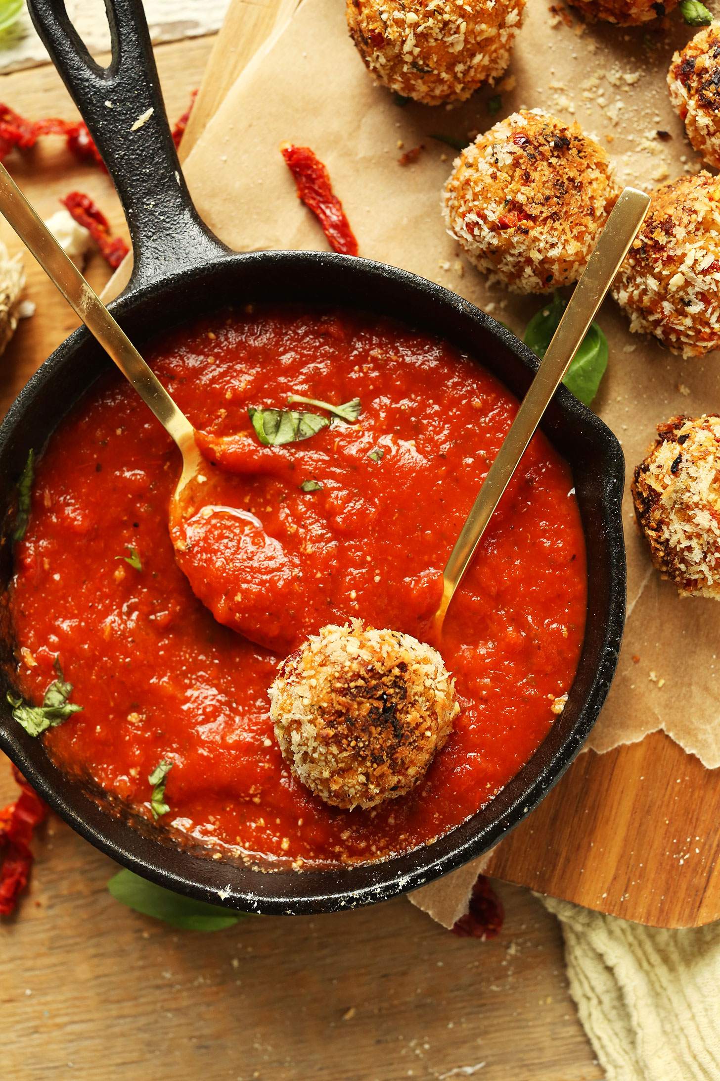 Cast-iron skillet showcasing our vegan Italian side dish of sun-dried tomato and basil arancini