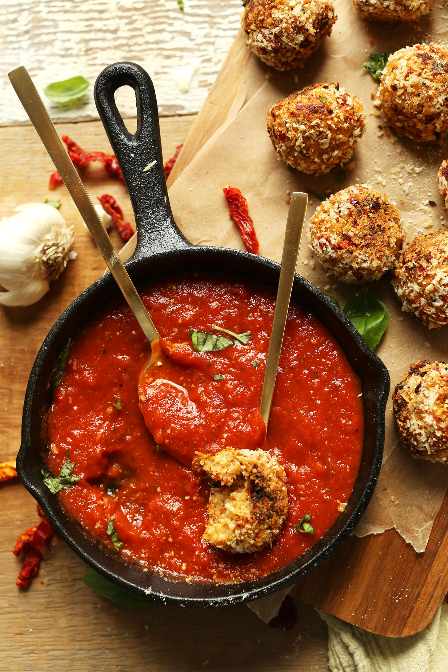 Dipping a ball of our Vegan Arancini recipe into marinara sauce