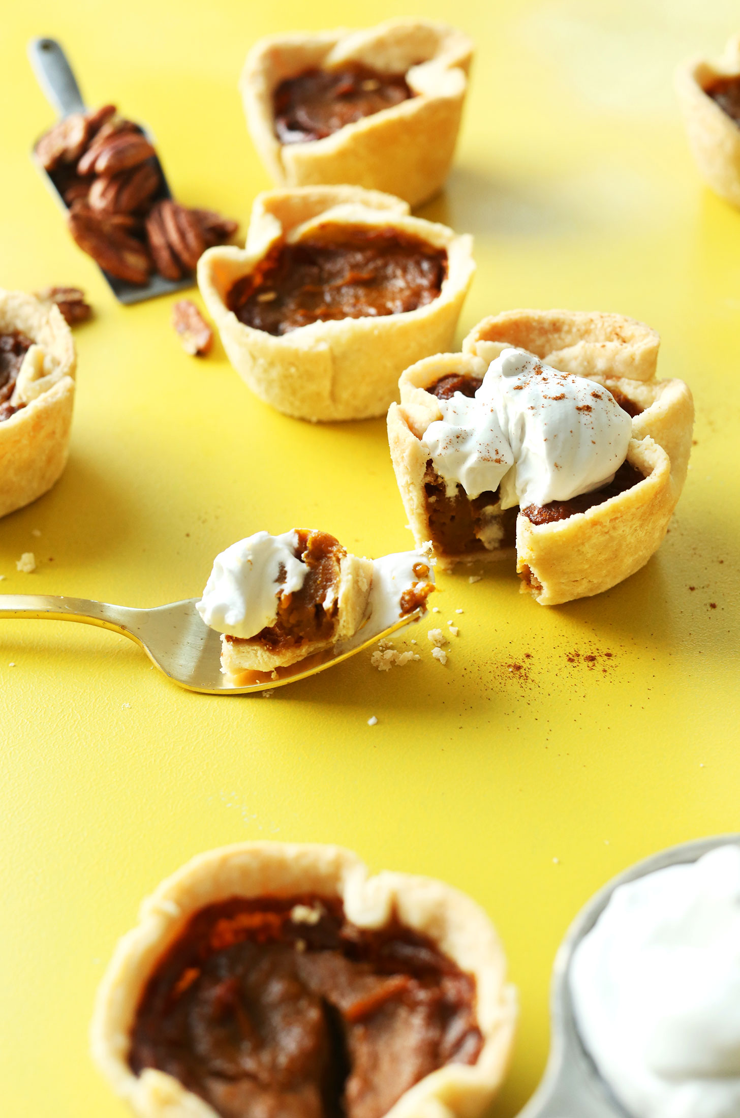 Taking a bite of a Mini Vegan Pumpkin Pie for the perfect fall dessert