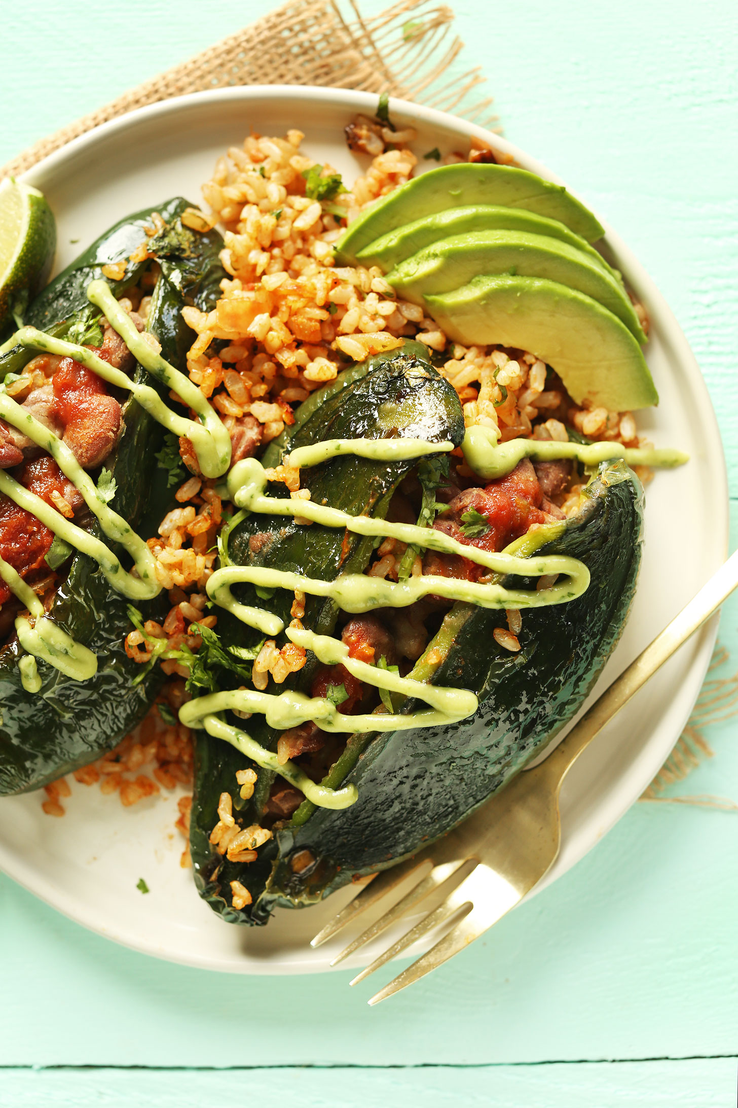 Stuffed poblano peppers drizzled with vegan avocado crema