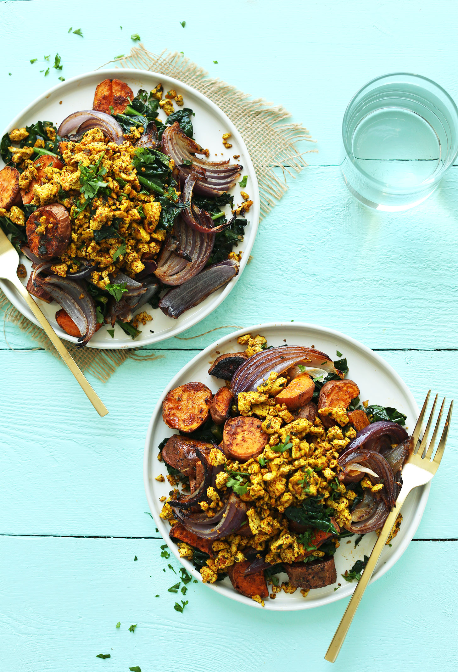 Two plates of our super healthy vegan breakfast of Savory Tofu Scramble with Kale, Sweet Potatoes, and Roasted Red Onion
