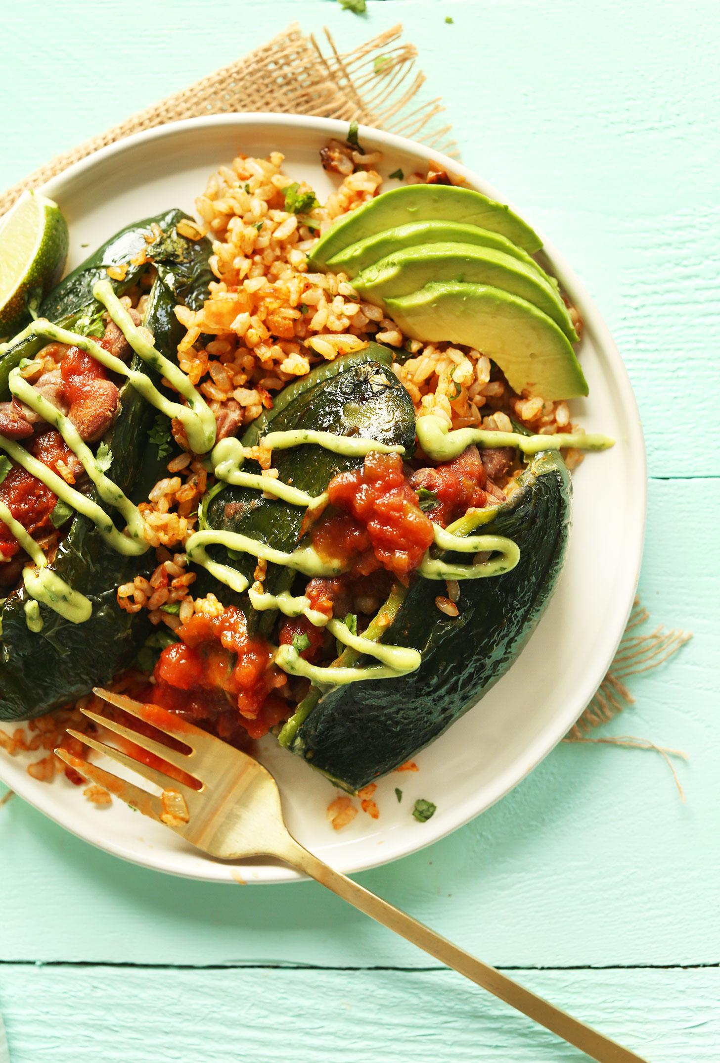 A plate of Vegan Mexican Stuffed Poblano Peppers drizzled with creamy avocado cilantro dressing