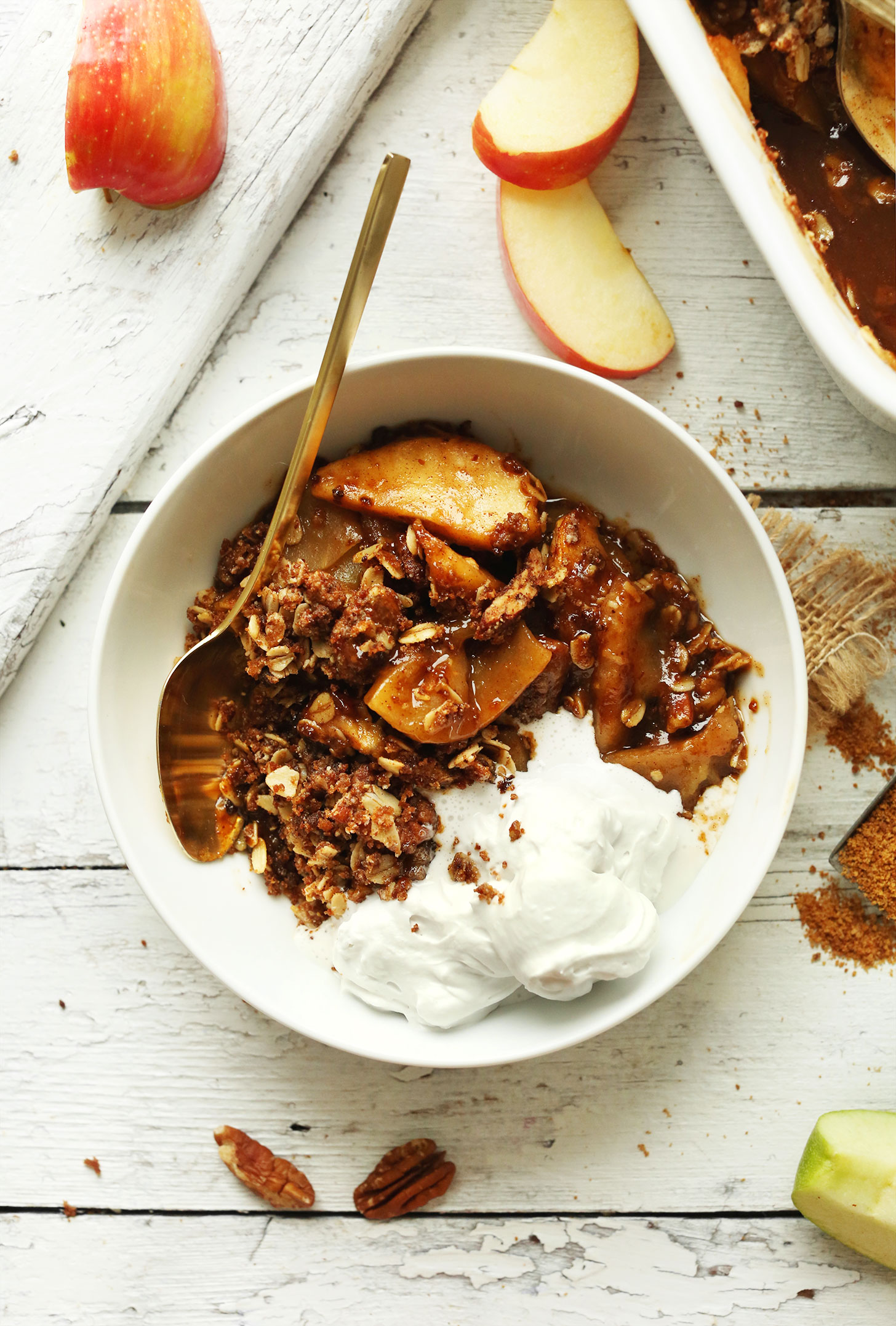 Close up shot of a bowl of Vegan Apple Crisp with Pecan-Oat Topping and ice cream