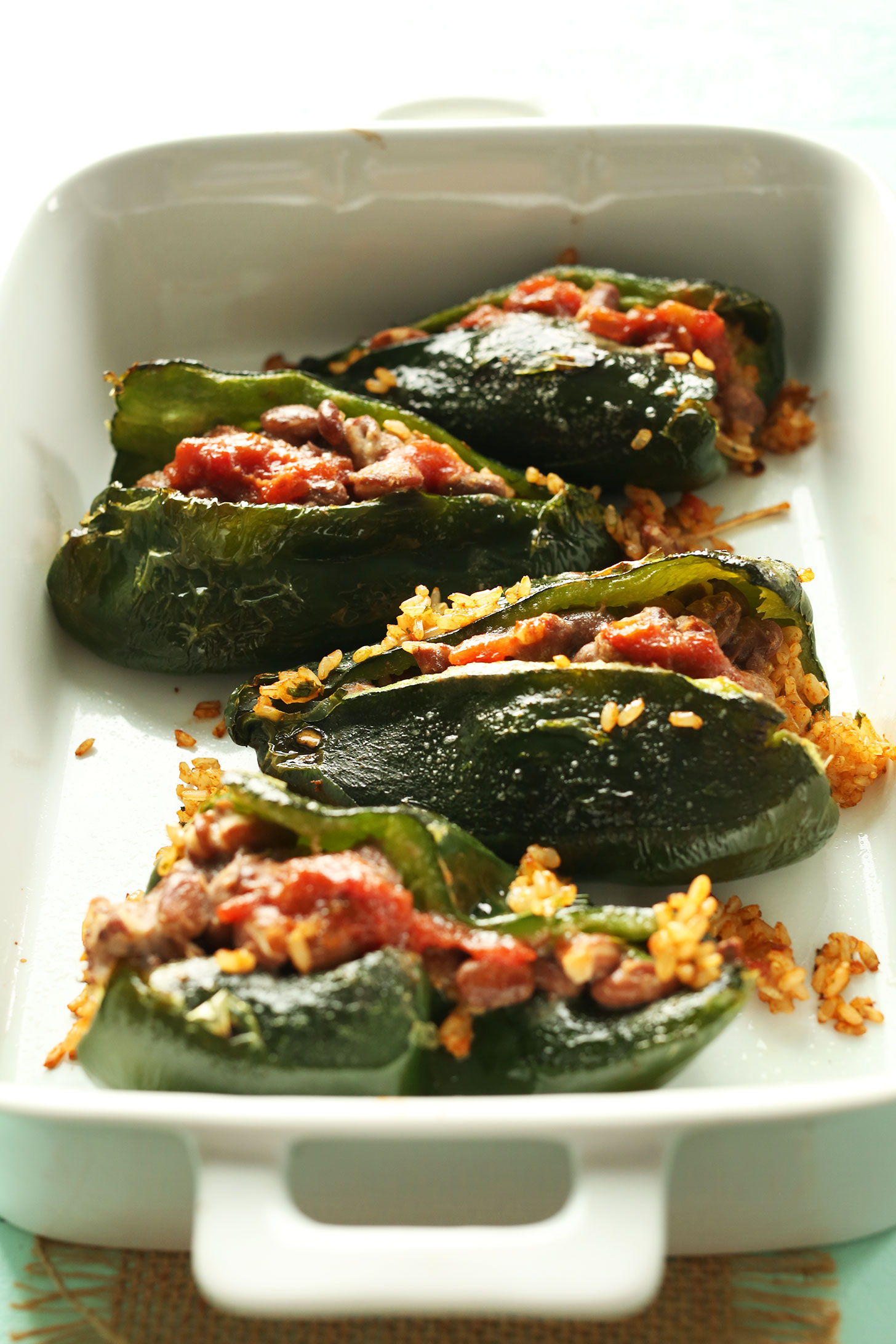 Baking pan of stuffed peppers with pinto beans, rice, and salsa