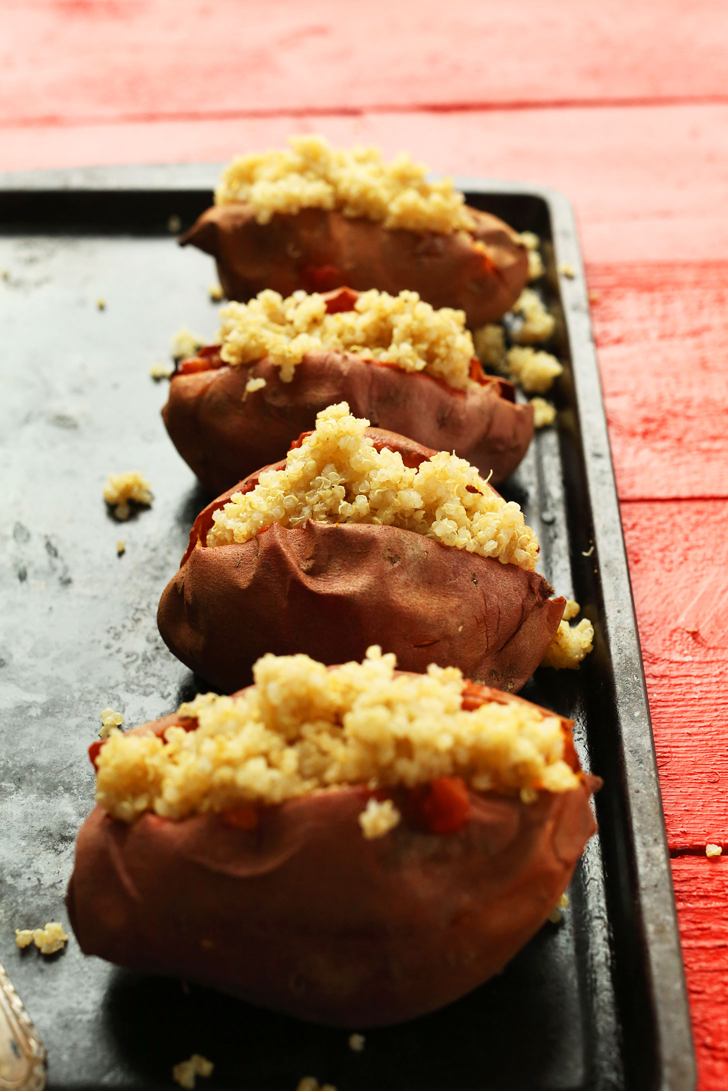 Baking sheet with sweet potatoes stuffed with quinoa as the base for a healthy vegan meal