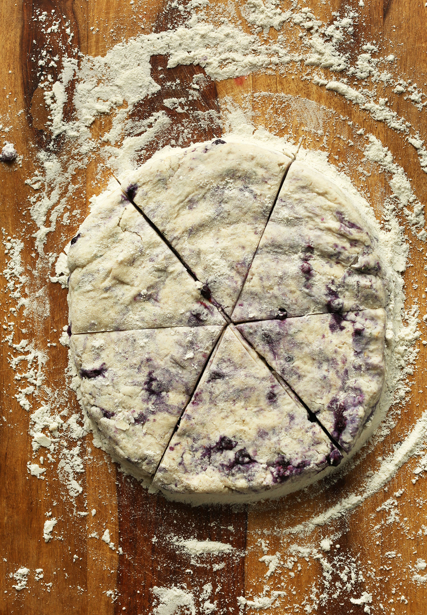 Freshly cut Vegan Blueberry Scones on a wood cutting board