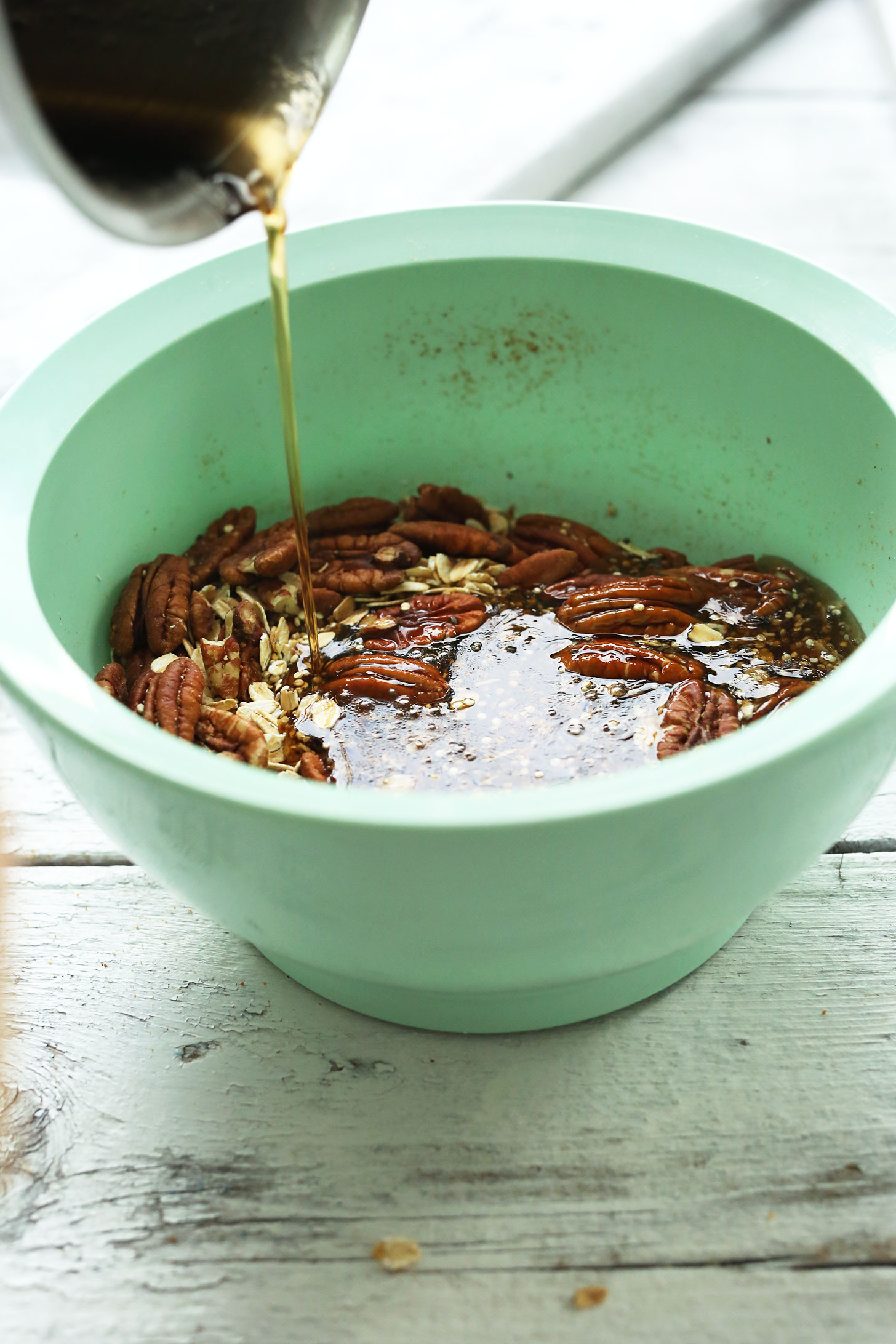 Pouring maple syrup into dry ingredients for homemade Quinoa Brittle