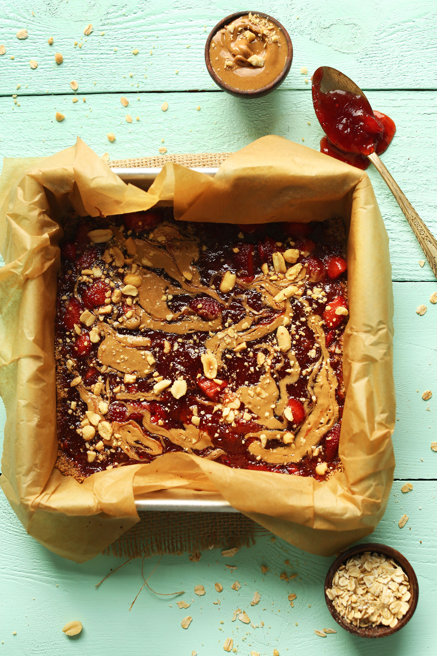 Parchment-lined baking pan filled with a batch of our PB&J Bars recipe for a gluten-free vegan snack