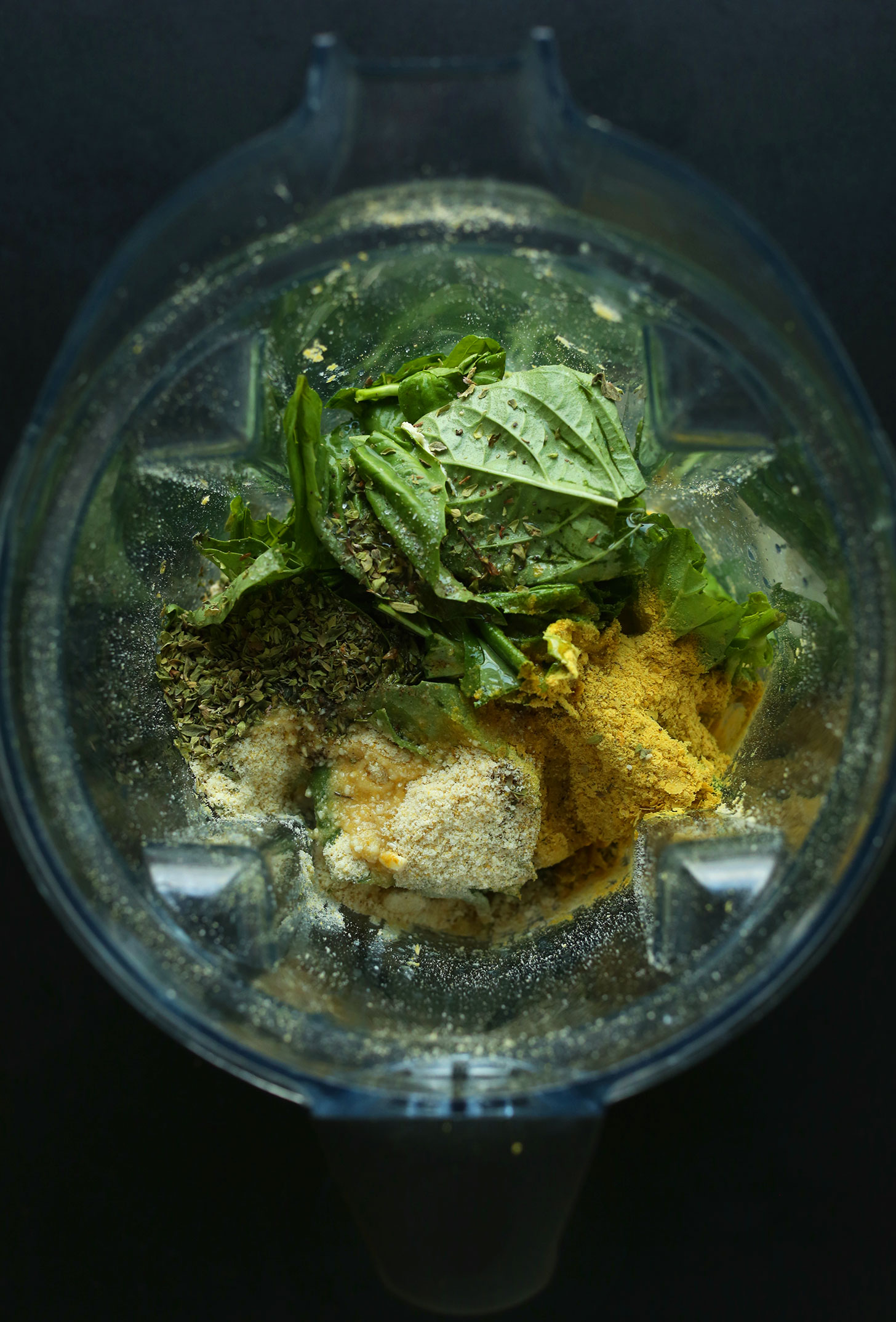 Blender filled with ingredients for making basil pesto sauce for vegan sweet potato lasagna
