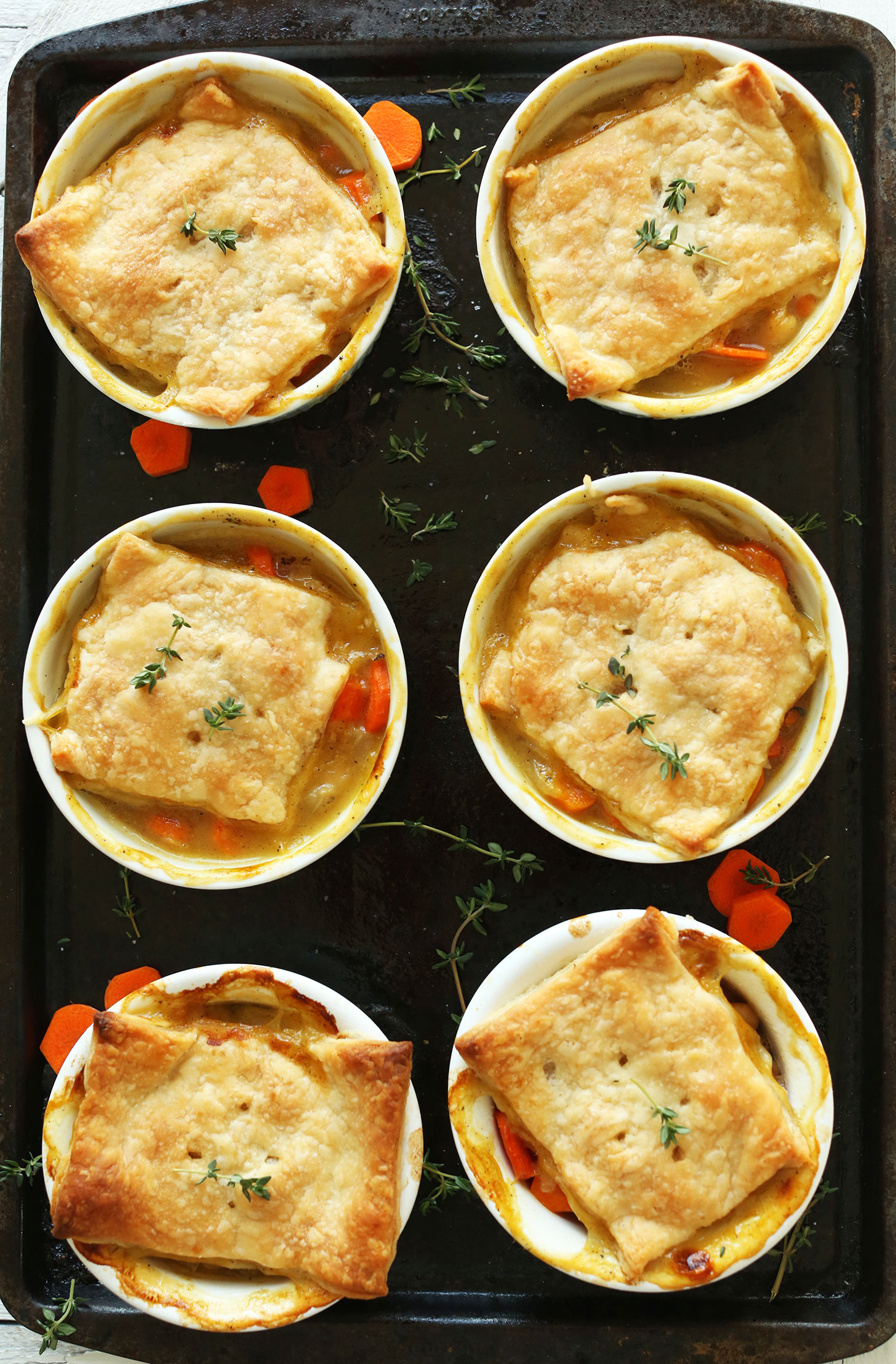 Baking sheet with six ramekins filled with White Bean & Thyme Vegan Pot Pies