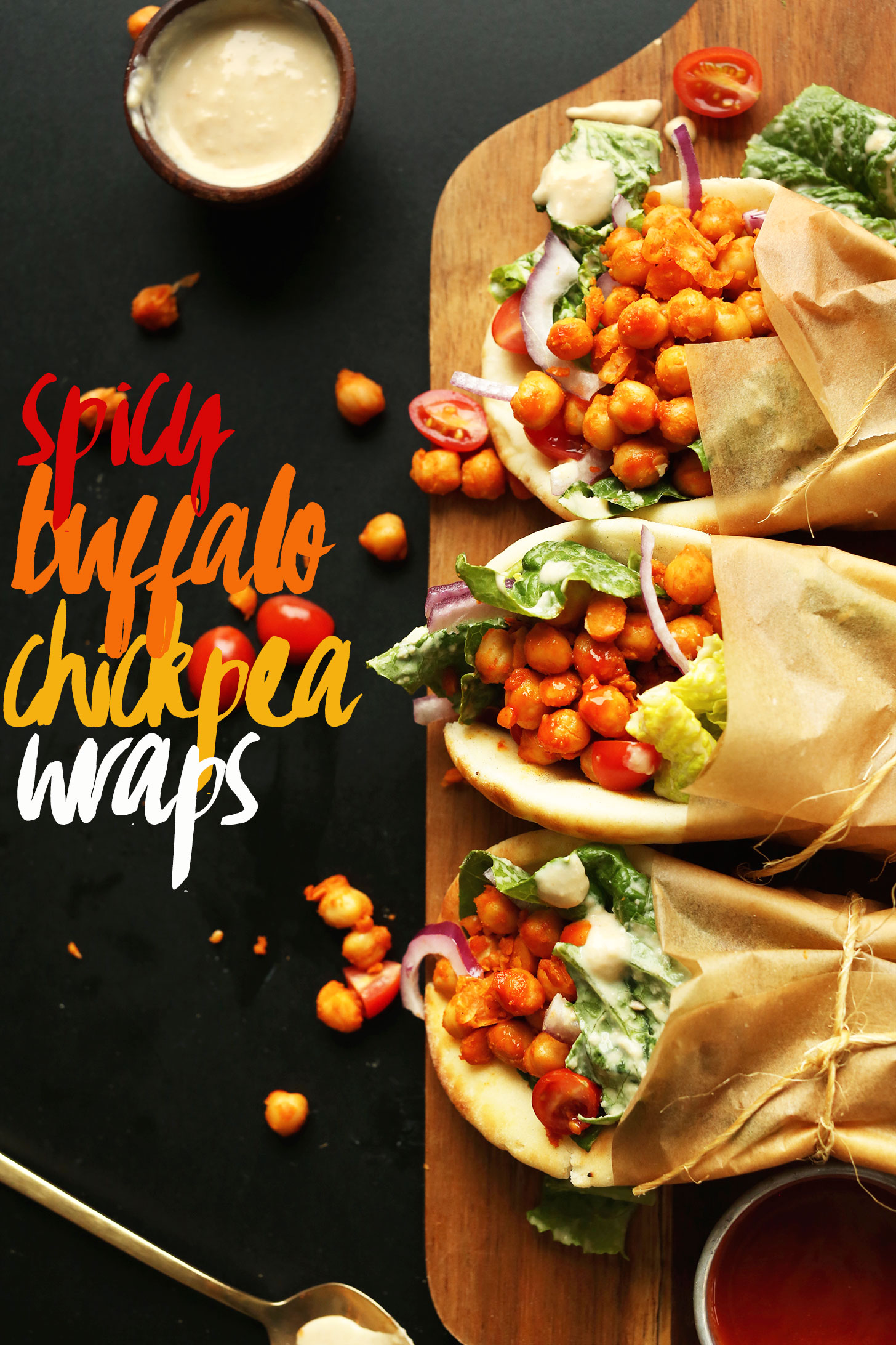 Rolled up vegan Buffalo Chickpea Wraps served on soft pita bread