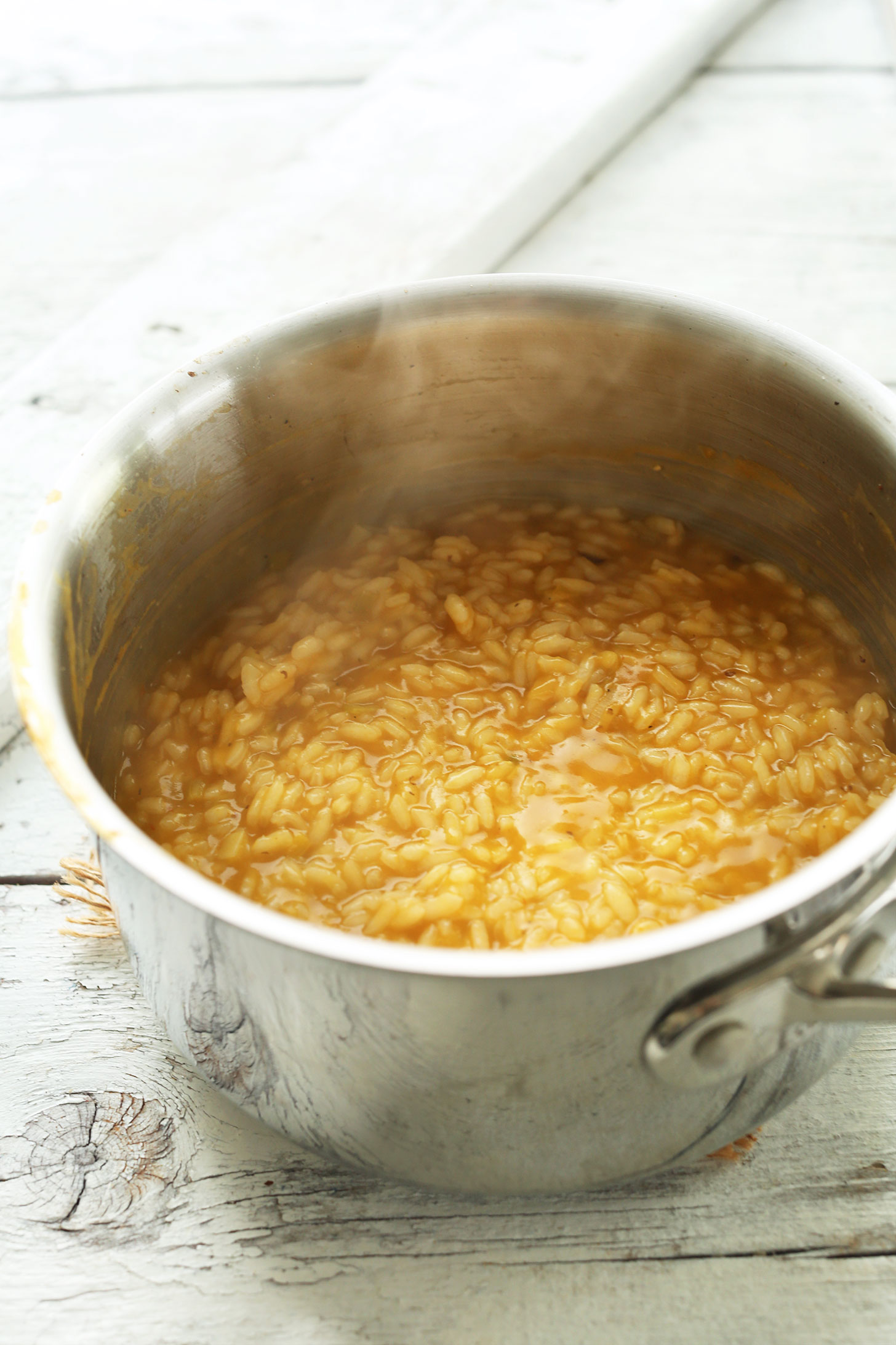 Cooking arborio rice in vegetable broth to make homemade Vegan Risotto