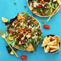 Bowl of pita bread triangles and two big plate of Chickpea Shawarma Salad