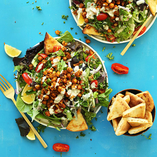 Bowl of pita bread triangles and two big plate of Chickpea Shawarma Salad
