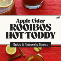 Cinnamon sticks, lemon slices, and glasses of our Apple Cider Rooibos Hot Toddy recipe with text that says spicy and naturally sweet