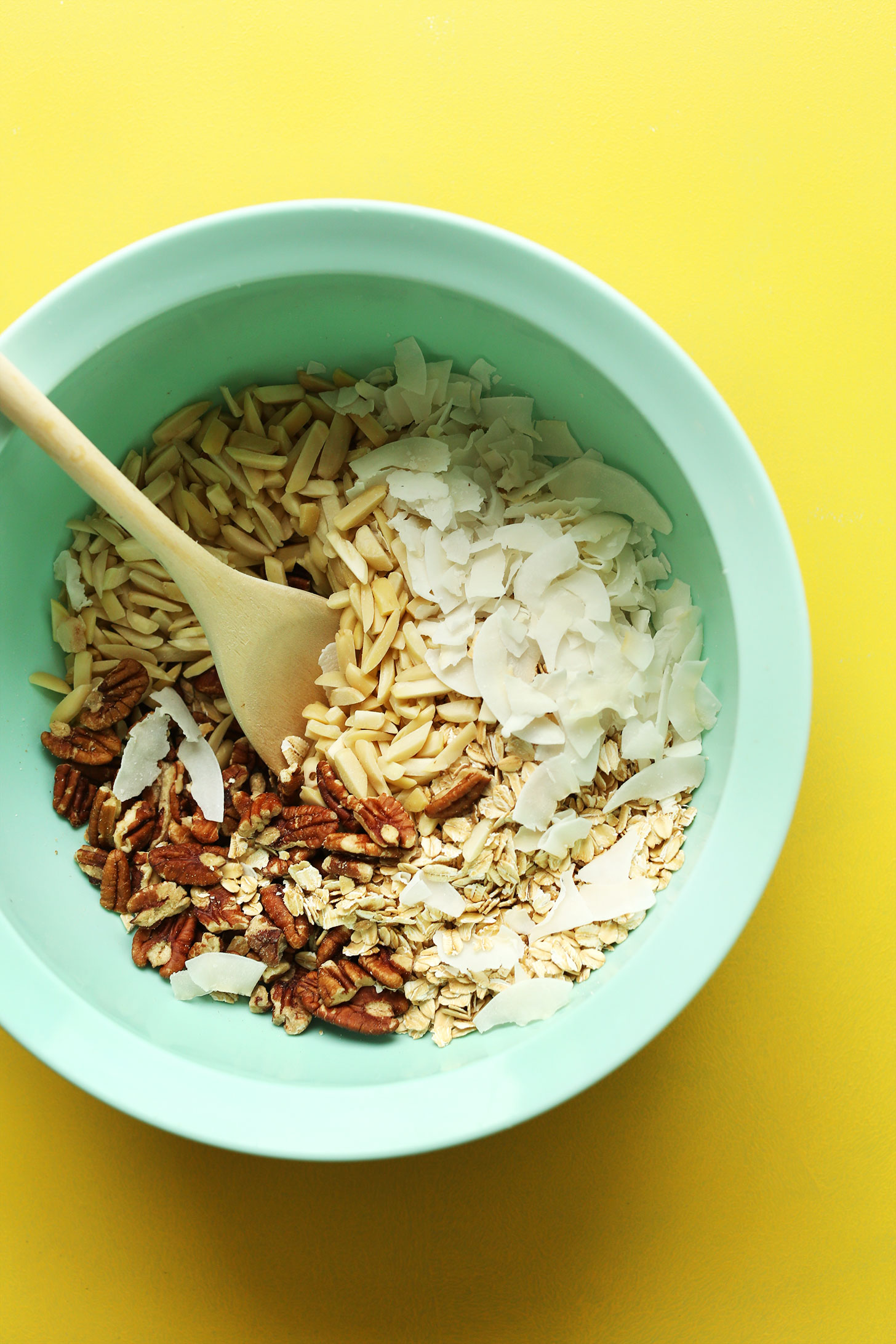 Mixing bowl with oats, nuts, and coconut for making gluten-free naturally-sweetened granola