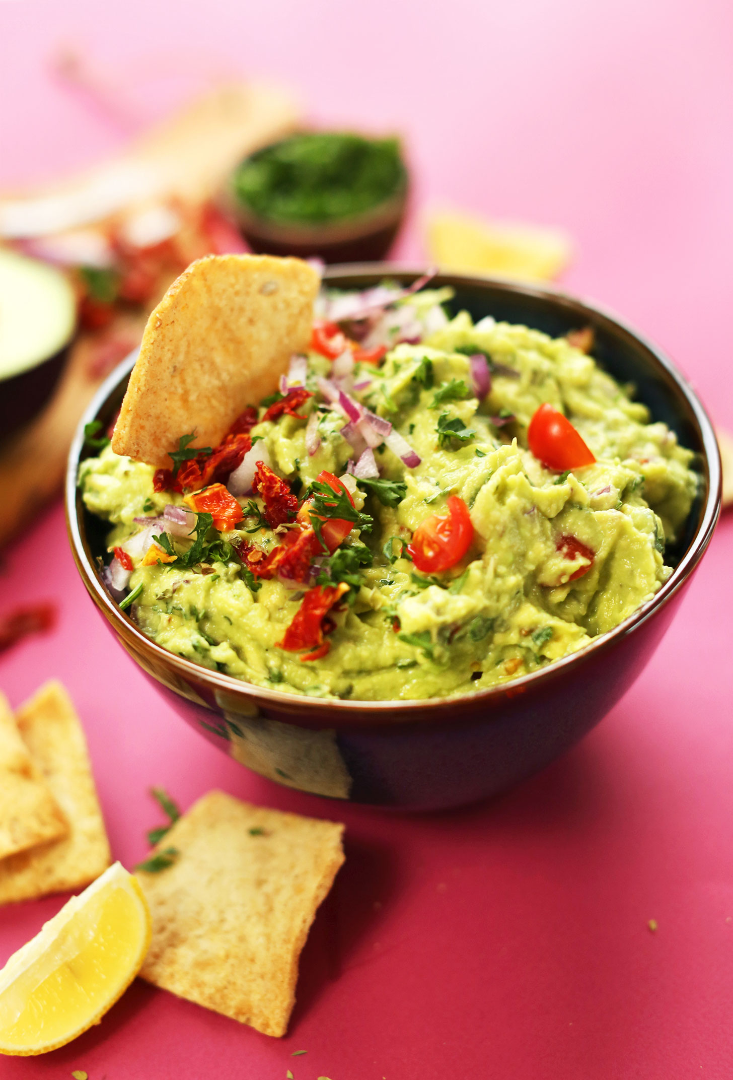Bowl of our delicious Greek-inspired Guacamole made with sun-dried tomatoes, red onion, lemon juice, and oregano