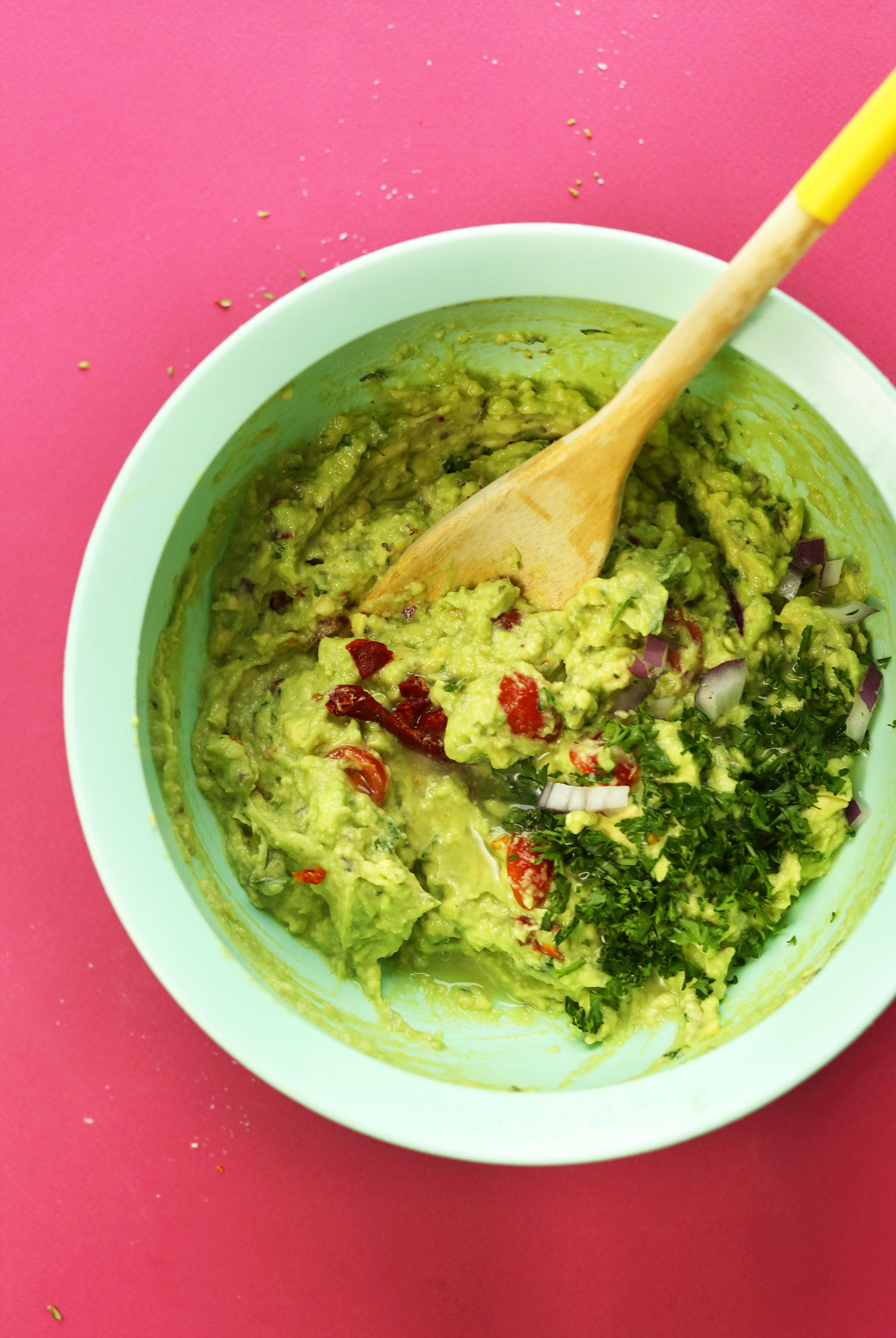 Stirring a big bowl of Greek-Inspired Guacamole for a nutritious plant-based snack