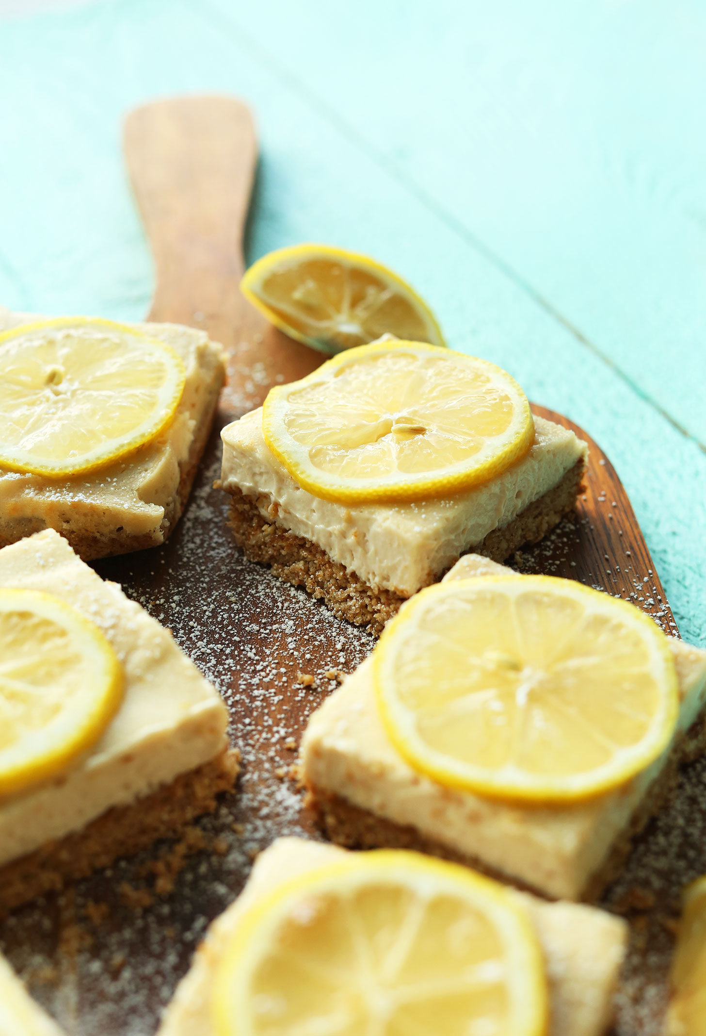 Board of homemade gluten-free vegan lemon bars sprinkled with powdered sugar