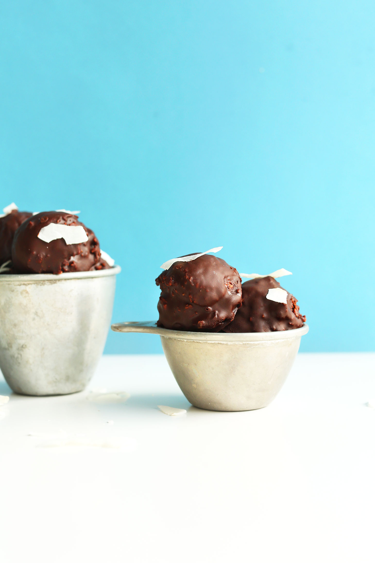 Measuring cups filled with our easy gluten-free vegan Double Chocolate Raw Macaroons recipe