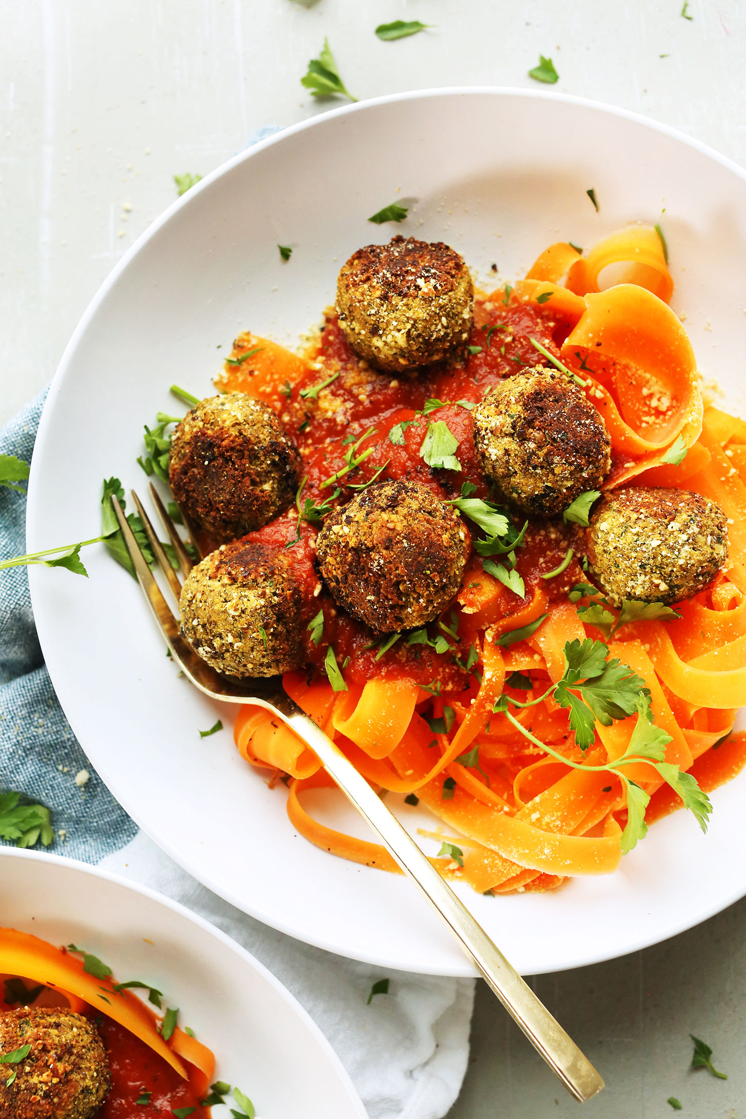Bowl of carrot ribbons topped with our easy vegan lentil meatballs recipe