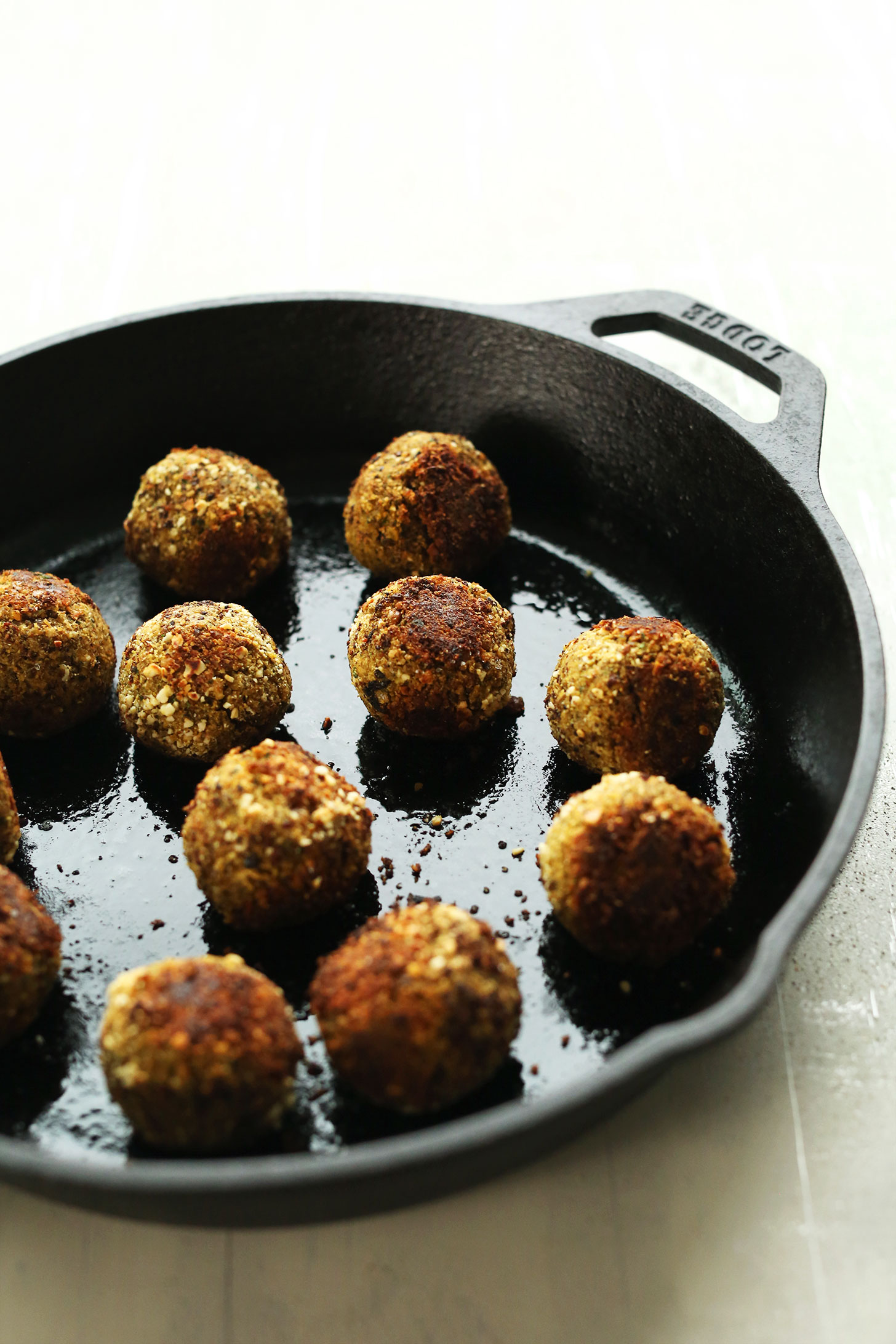 Browning vegan lentil meatballs in a cast-iron skillet for a delicious plant-based meal
