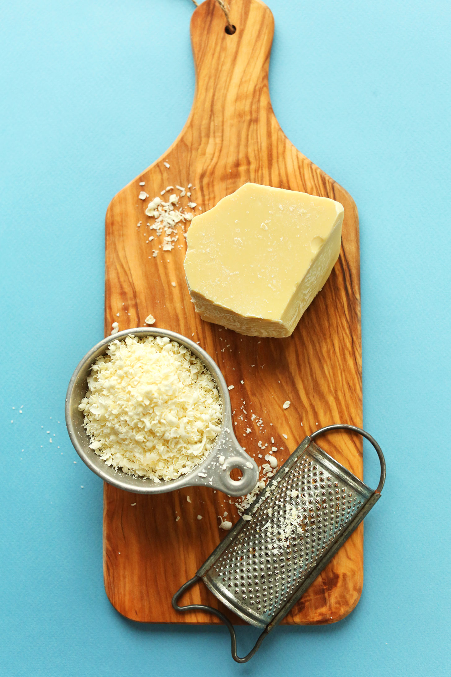 Cutting board with freshly grated raw cacao butter for making Double Chocolate Macaroons