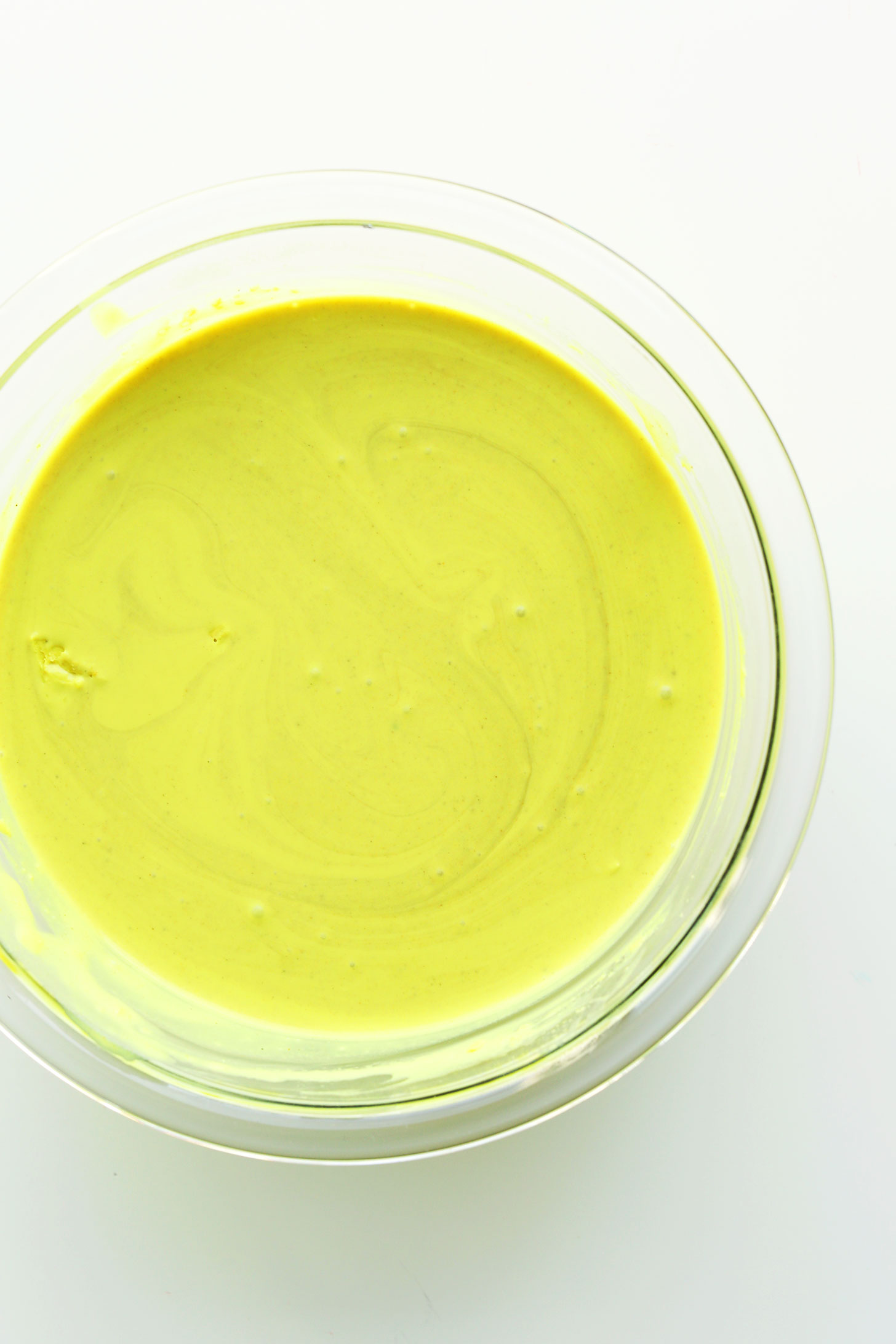 Bowl of vibrant yellow golden milk ready to be made into homemade vegan ice cream for dessert