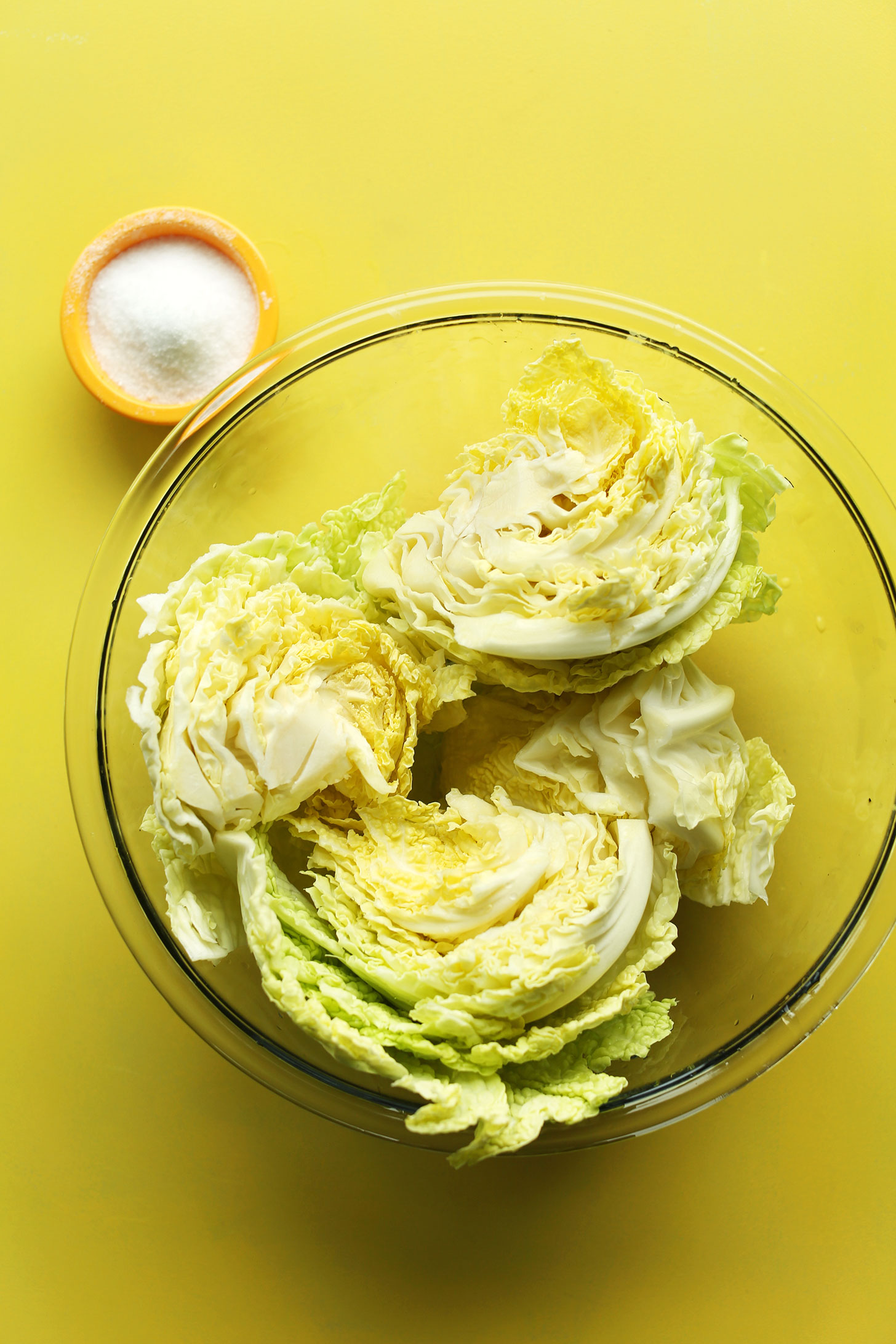 Bowls of cabbage and salt for making delicious our easy vegan kimchi recipe