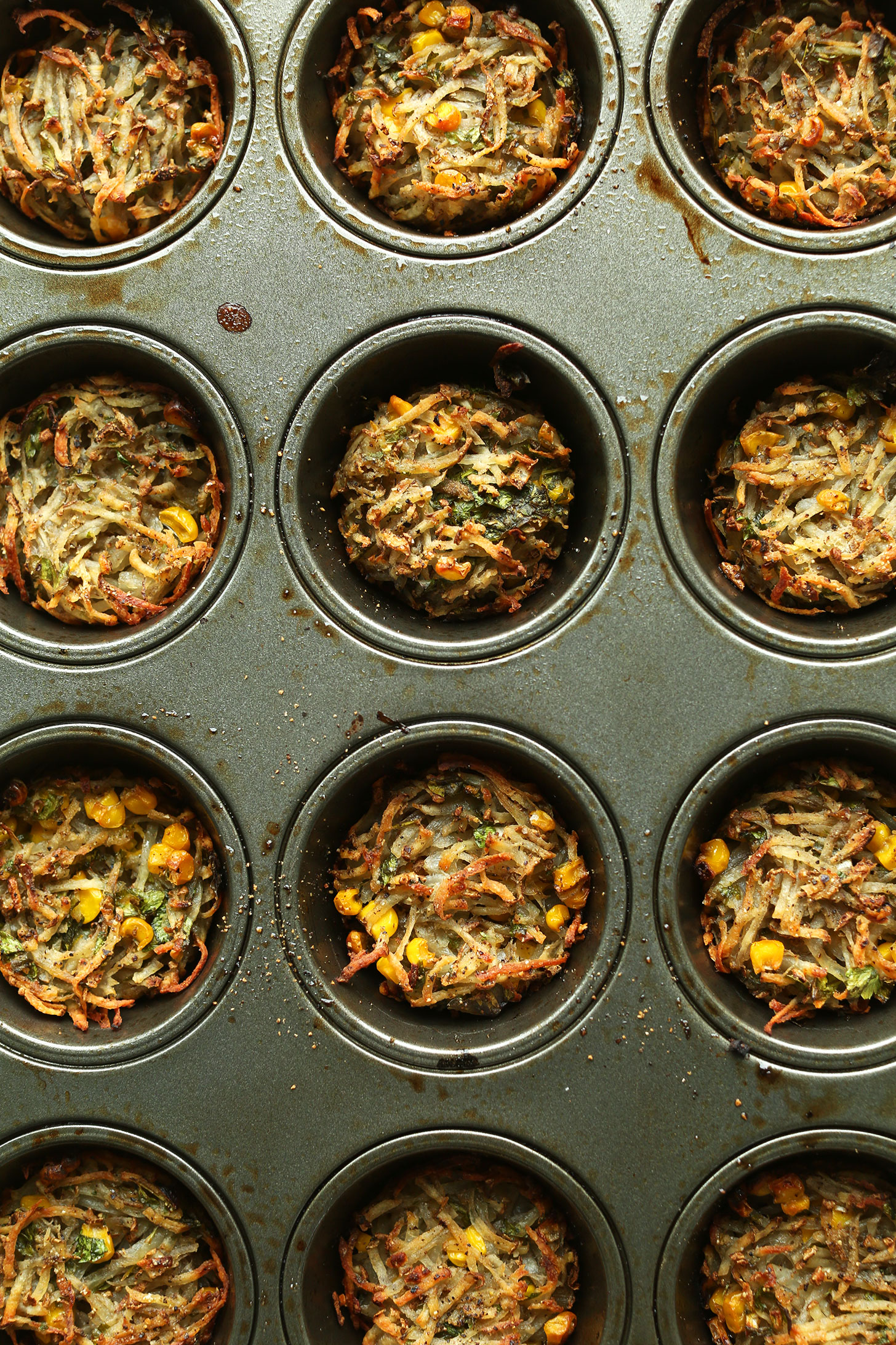 Muffin tin filled with hashbrown mixture for making Crispy Baked Hashbrowns